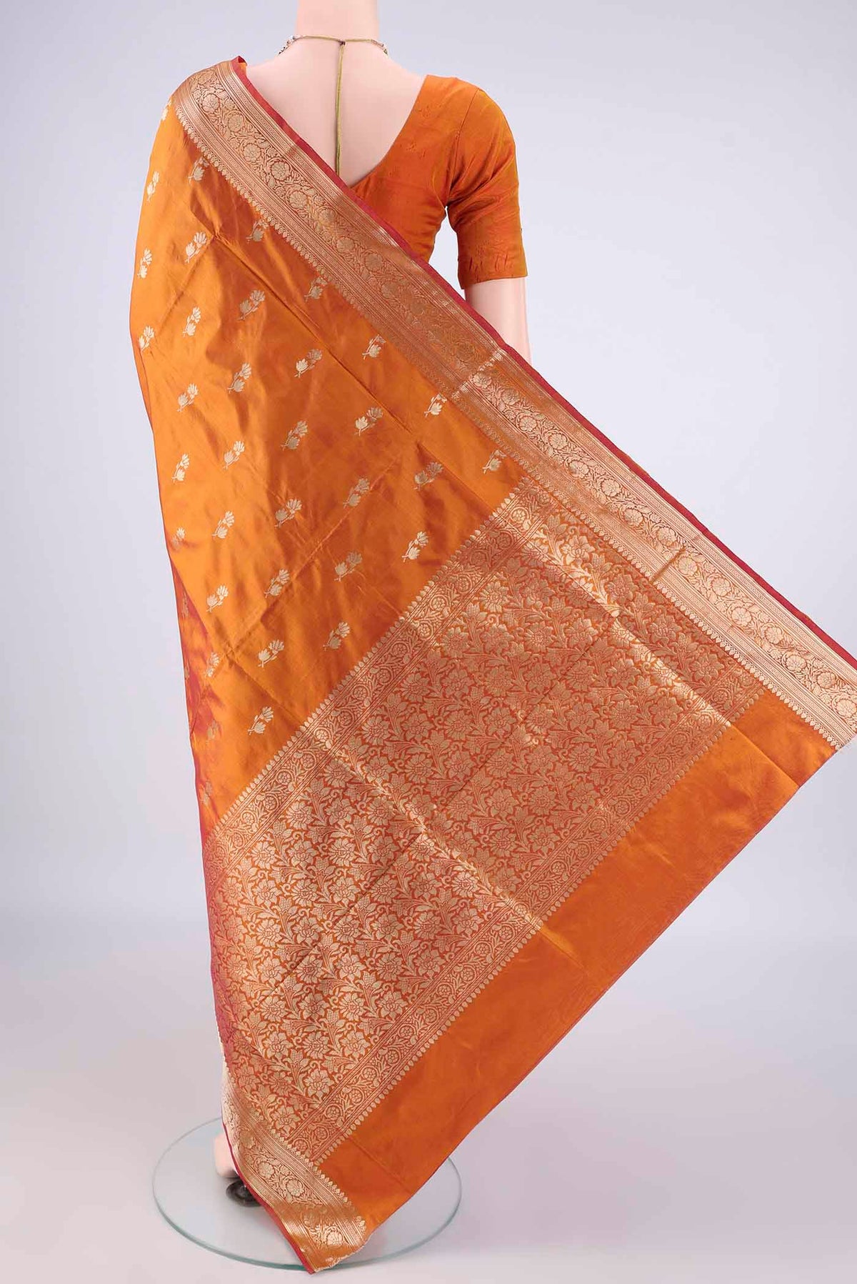 Flat view of Pure Silk Brick Orange Banarasi Katan Saree with Zari Butta on the body and Zari Border. 