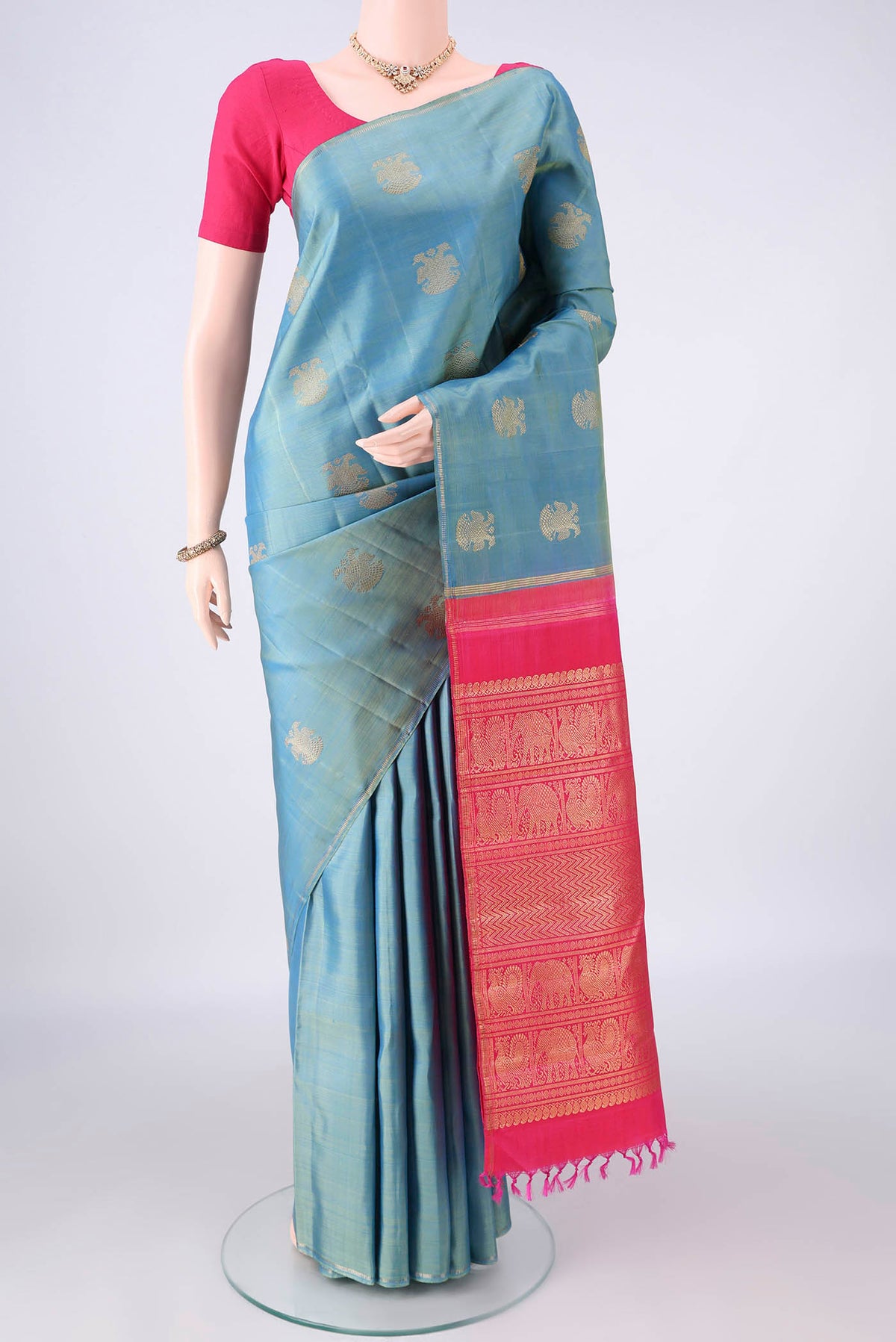 Pure Silk Pure Zari Light Blue Dual Tone Kanchipuram Saree with Zari Butta on the body and Thin Zari Line.  displayed on a mannequin