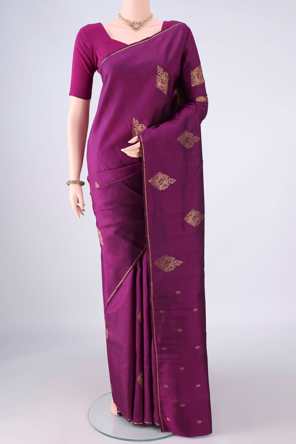 Pure Silk Pure Zari Magenta Kanchipuram Saree with Zari Butta on the body and Thin Zari Line.  displayed on a mannequin