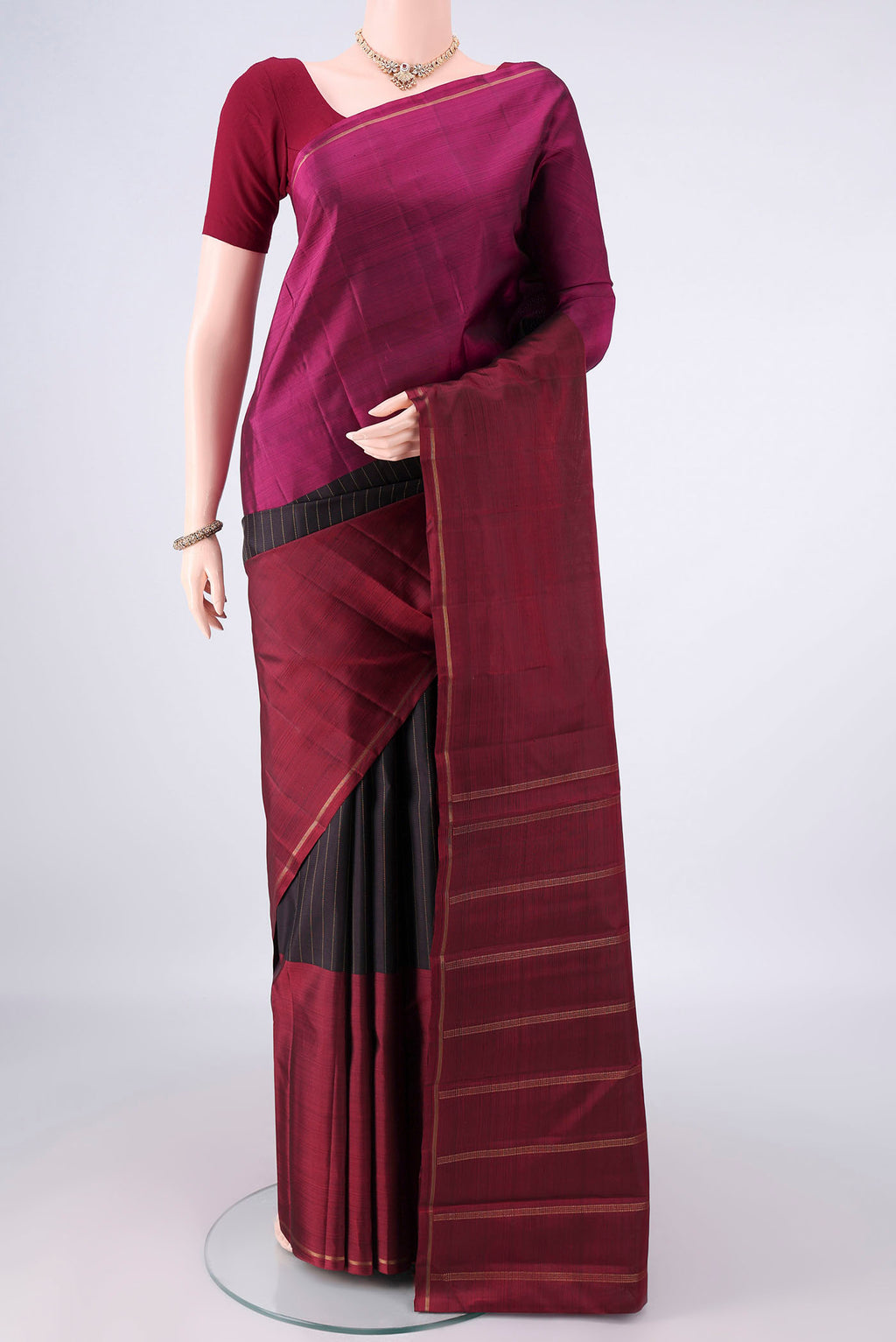 Pure Silk Black Kanjivaram Saree with Stripes on the body and Ganga Jamuna Border.  displayed on a mannequin