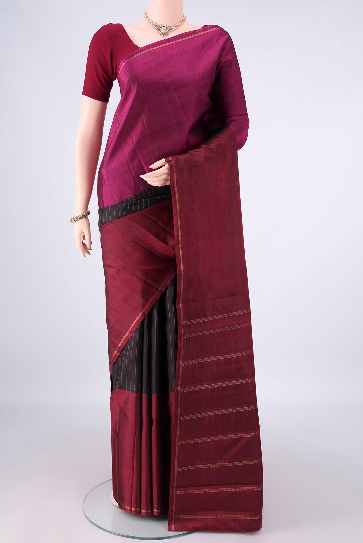 Pure Silk Black Kanjivaram Saree with Stripes on the body and Ganga Jamuna Border.  displayed on a mannequin