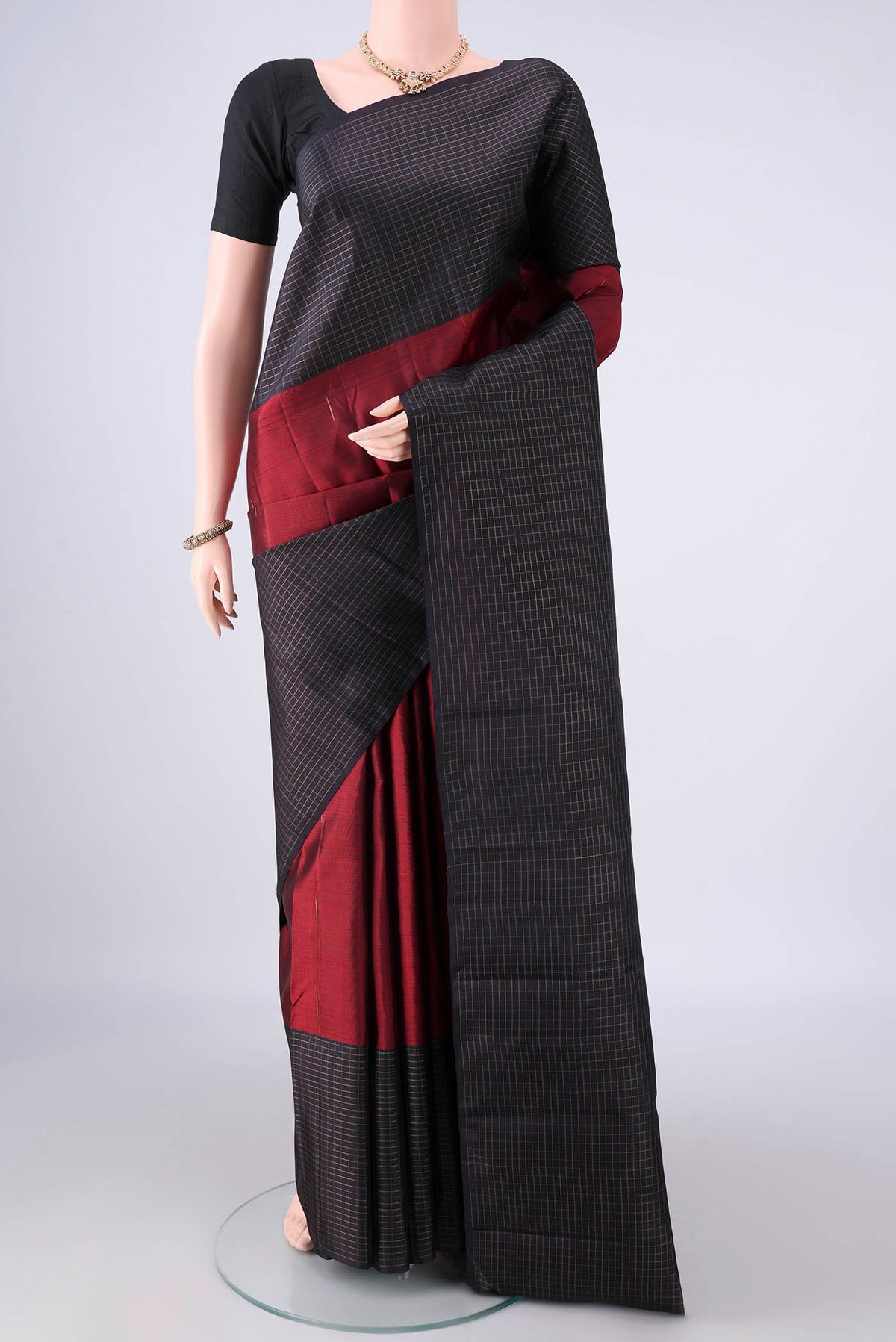 Pure Silk Maroon Kanchipuram Saree with Zari Butta on the body and Checks Border.  displayed on a mannequin