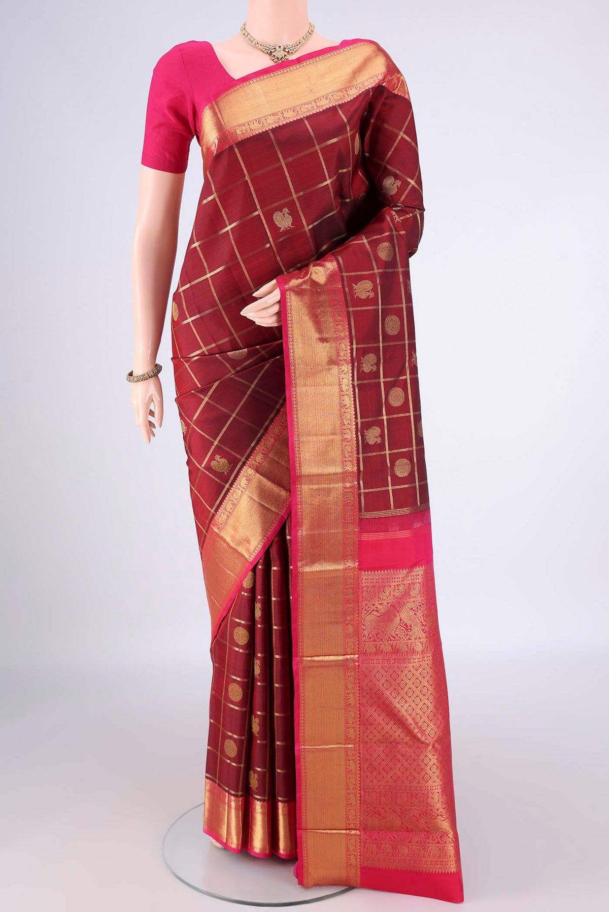 Pure Silk Maroon Kanjivaram Saree with Checked design on the body and Zari Border.  displayed on a mannequin