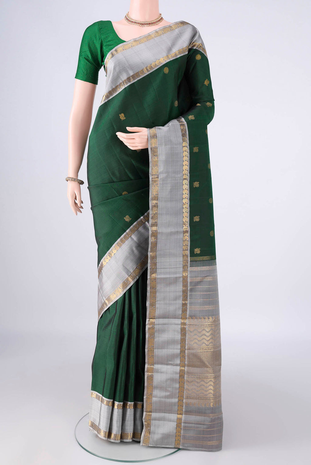Pure Silk Pure Zari Bottle Green Kanchipuram Saree with Zari Butta on the body and Zari Border.  displayed on a mannequin