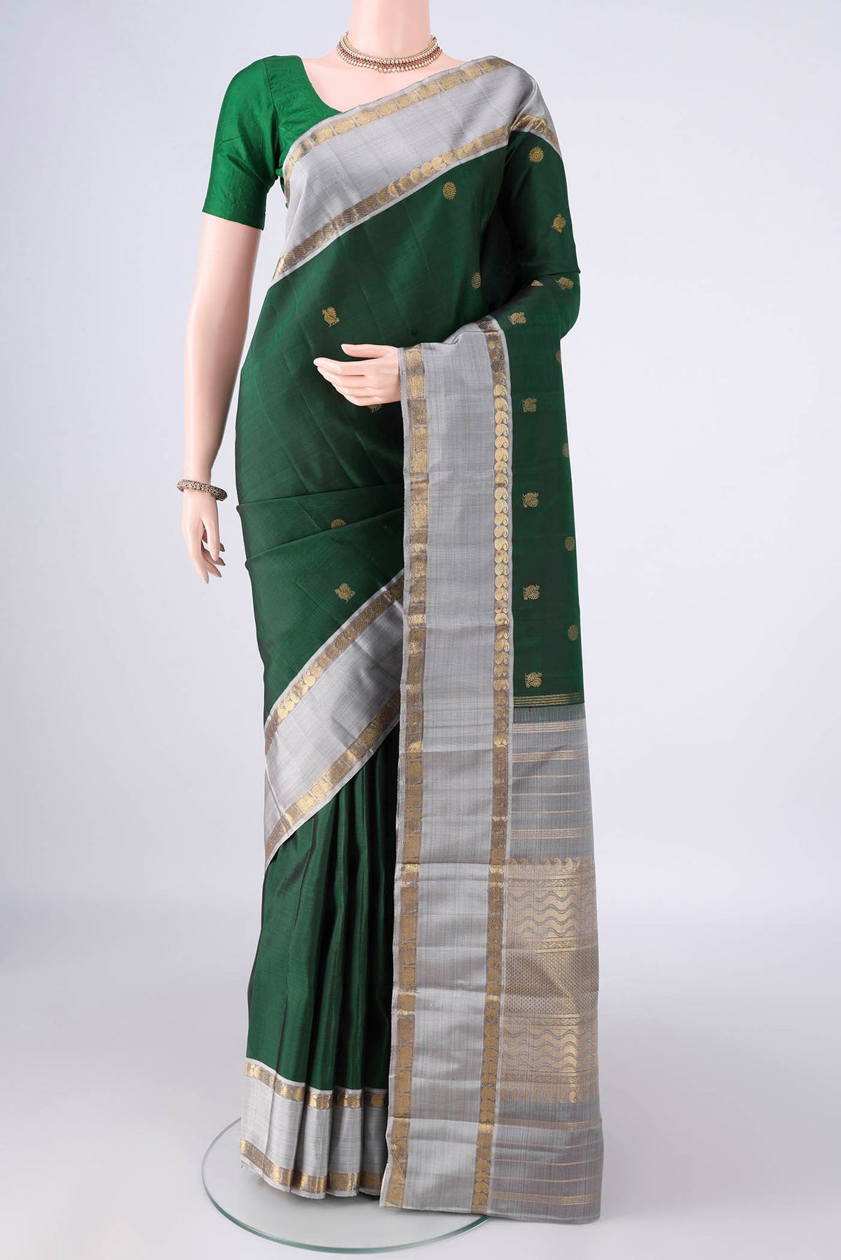 Pure Silk Pure Zari Bottle Green Kanchipuram Saree with Zari Butta on the body and Zari Border.  displayed on a mannequin