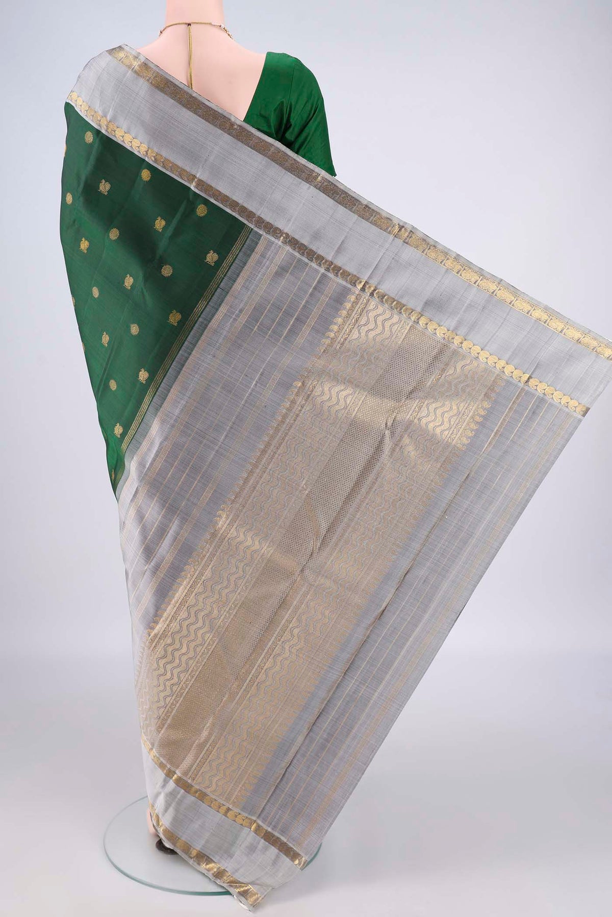 Flat view of Pure Silk Pure Zari Bottle Green Kanchipuram Saree with Zari Butta on the body and Zari Border. 