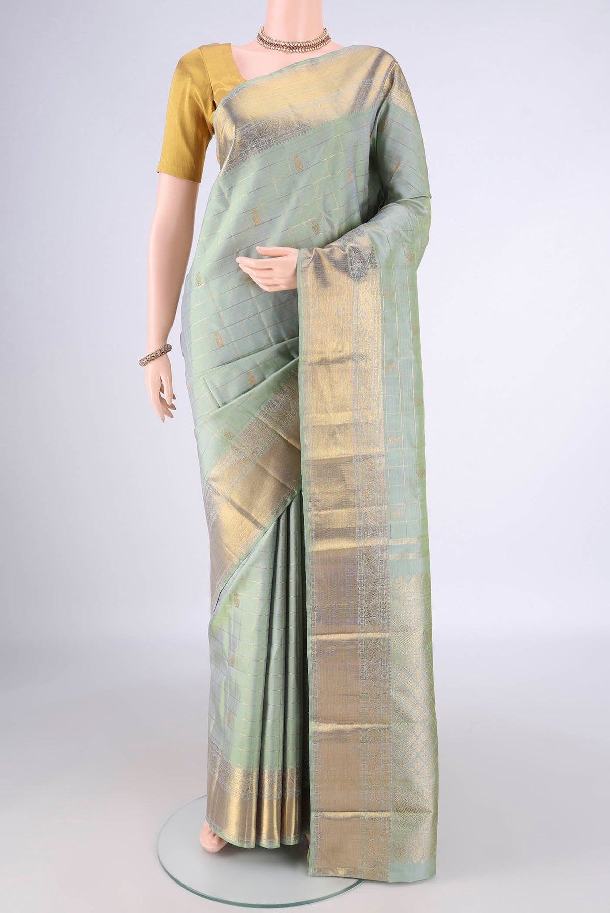 Pure Silk Pure Zari Pista Green Kanjivaram Saree with Checked design on the body and Zari Border.  displayed on a mannequin