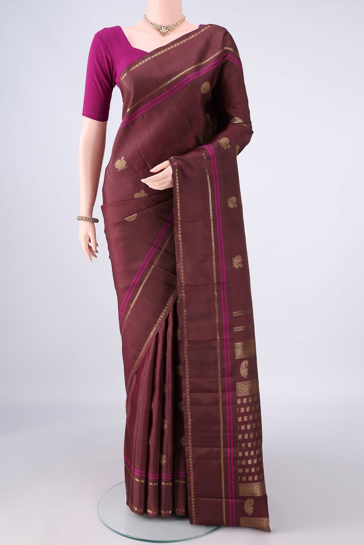 Pure Silk Brown Kanchipuram Saree with Zari Butta on the body and Plain Border.  displayed on a mannequin
