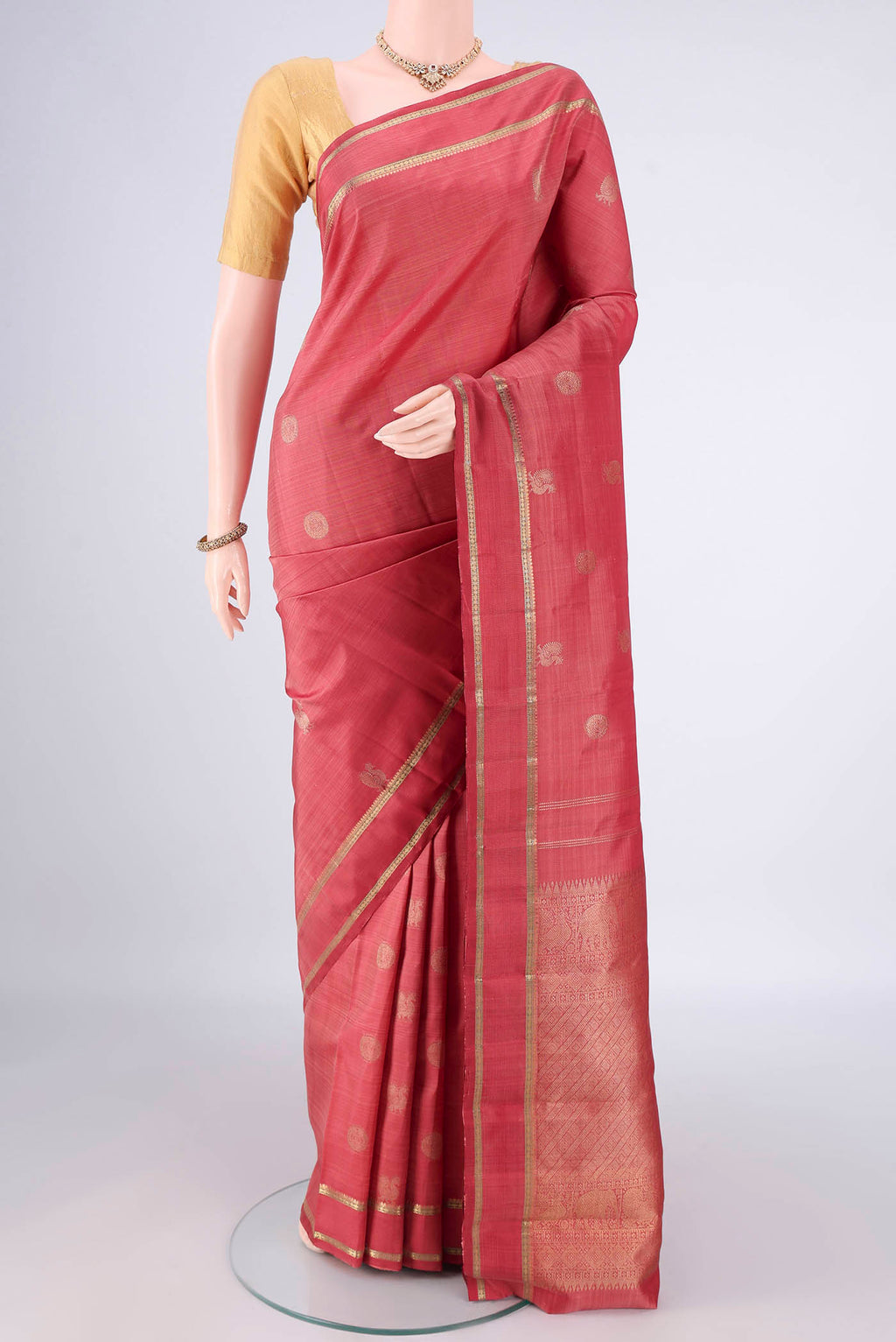 Pure Silk Pure Zari Coral Kanchipuram Saree with Zari Butta on the body and Zari Border.  displayed on a mannequin