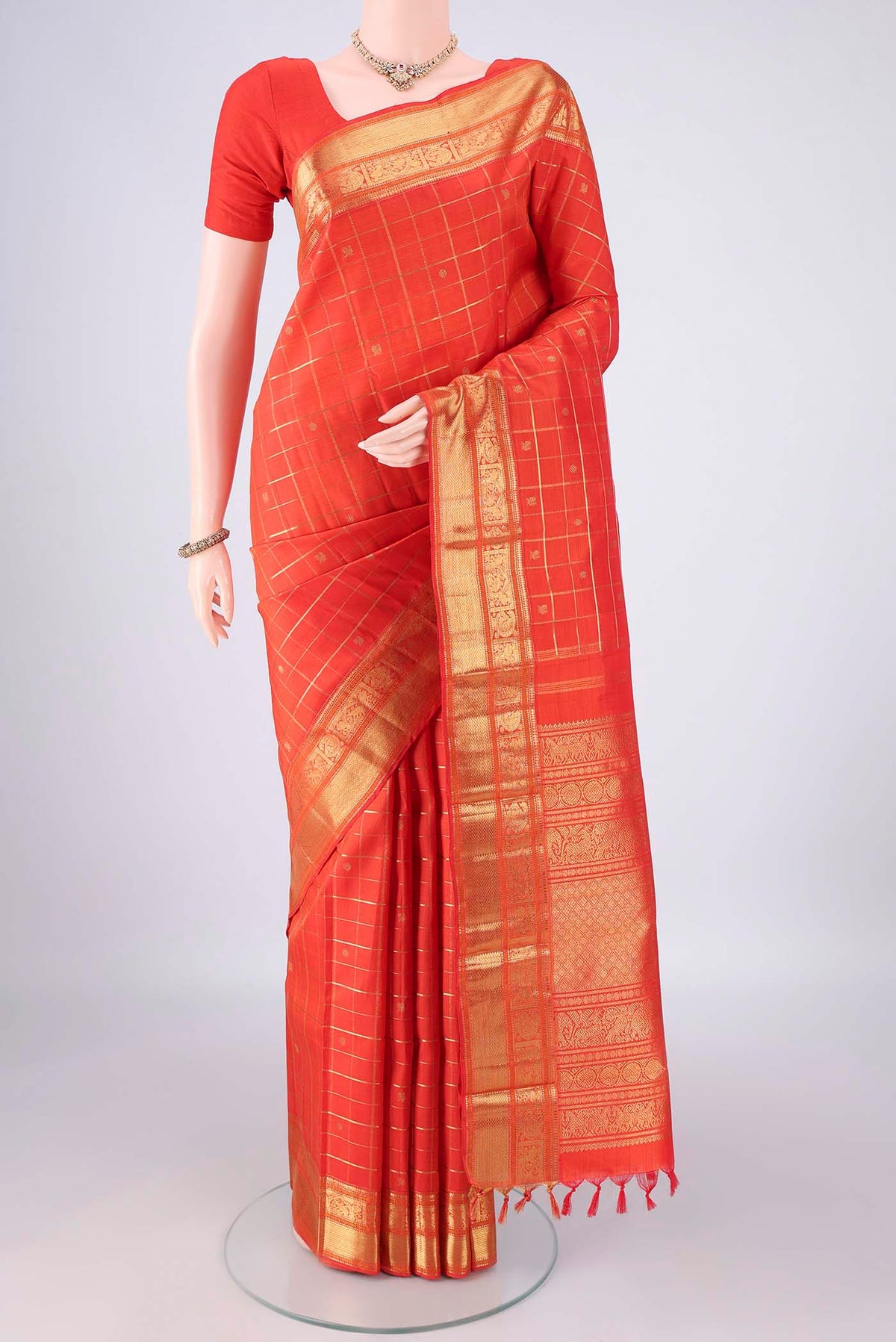 Pure Silk Pure Zari Orange Kanjivaram Saree with Checked design on the body and Zari Border.  displayed on a mannequin
