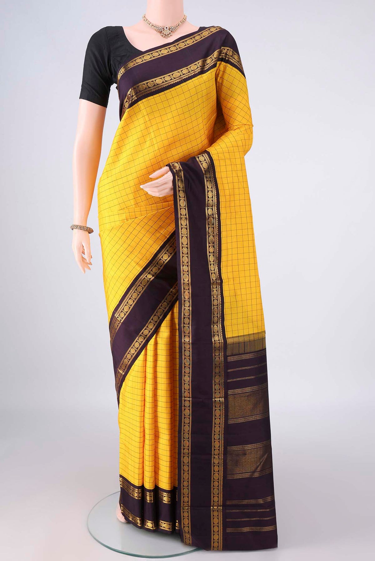 Pure Silk Pure Zari Yellow Kanjivaram Saree with Checked design on the body and Plain Border.  displayed on a mannequin