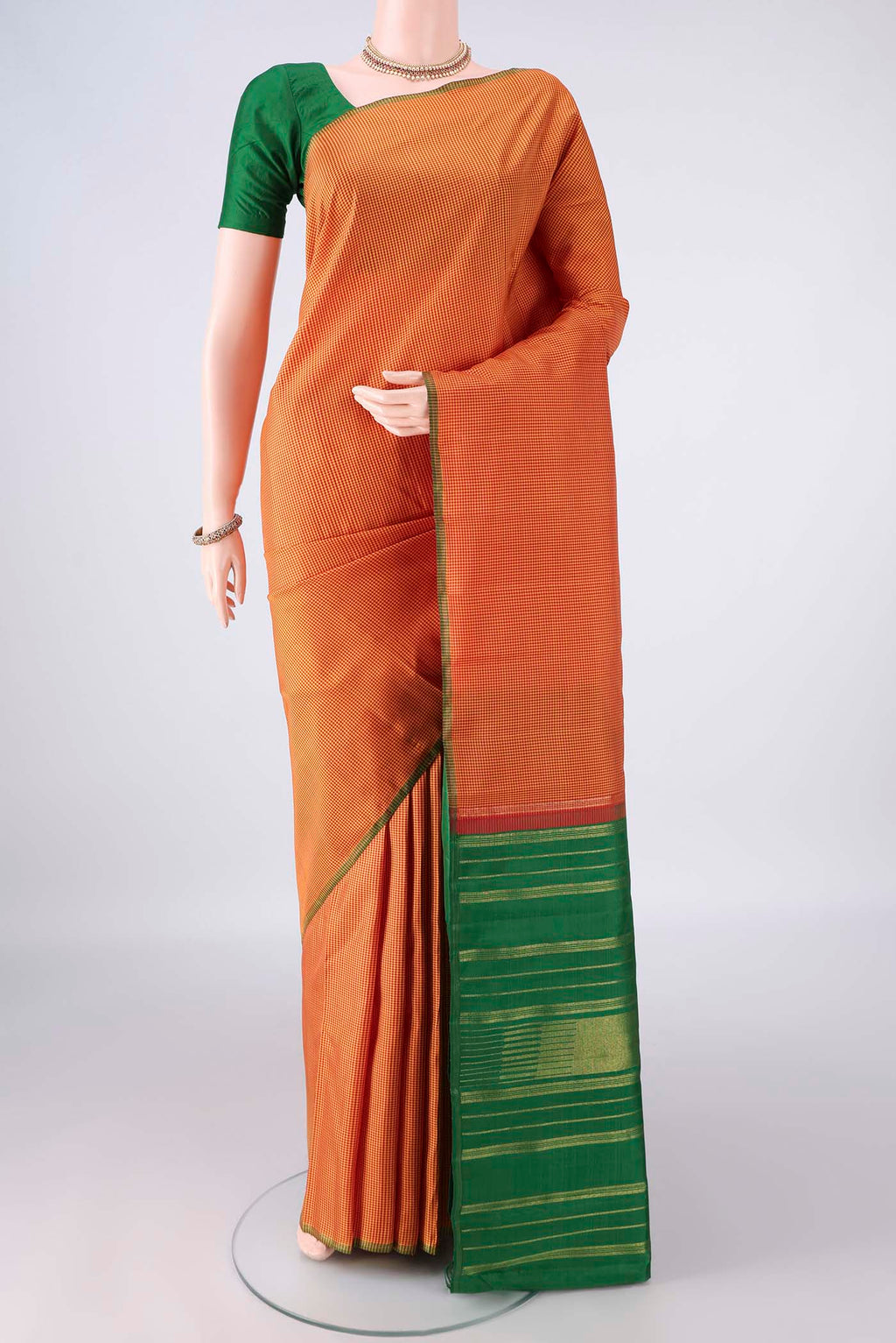 Pure Silk Brick Orange Kanjivaram Saree with Checked design on the body and Without Border.  displayed on a mannequin