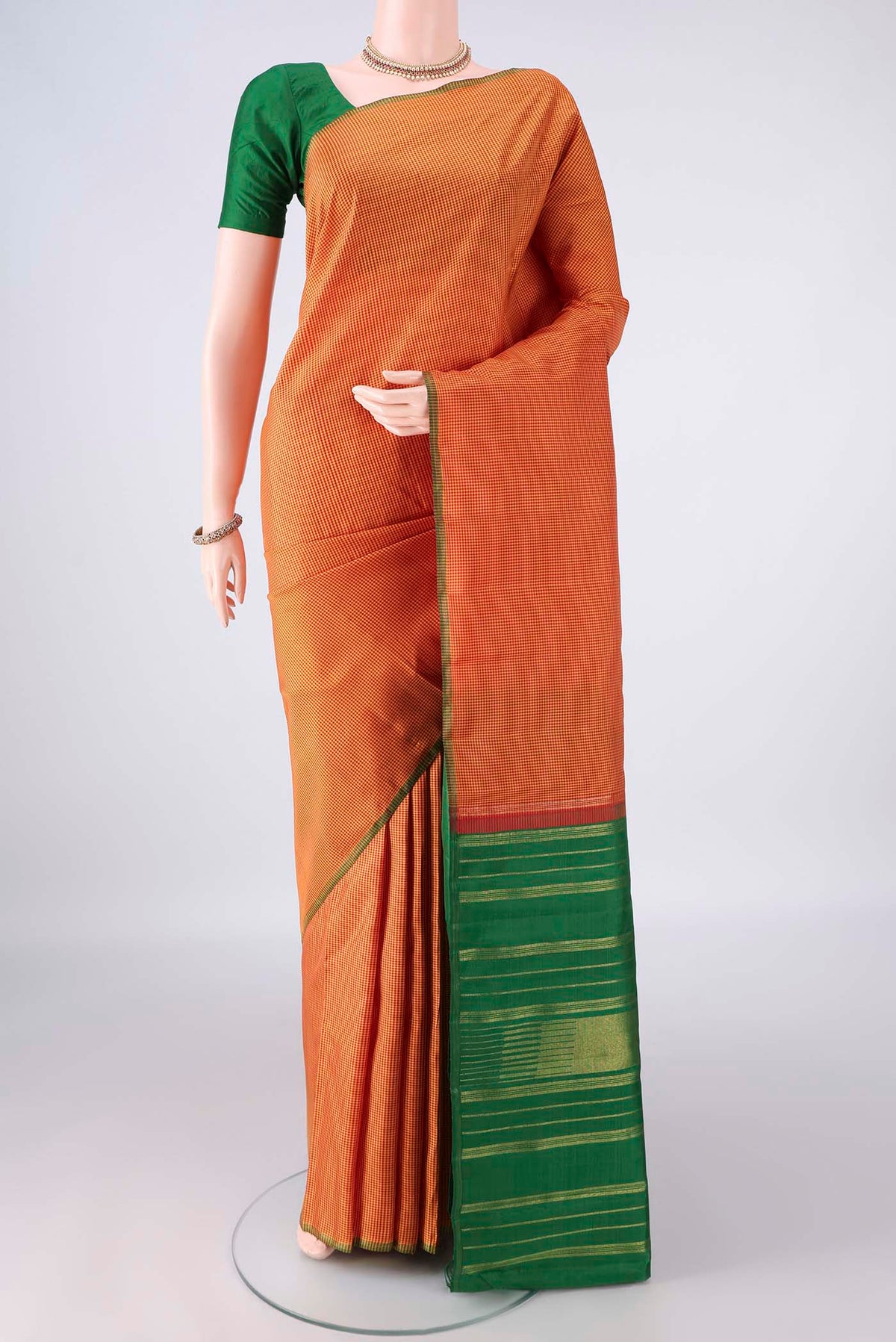 Pure Silk Brick Orange Kanjivaram Saree with Checked design on the body and Without Border.  displayed on a mannequin