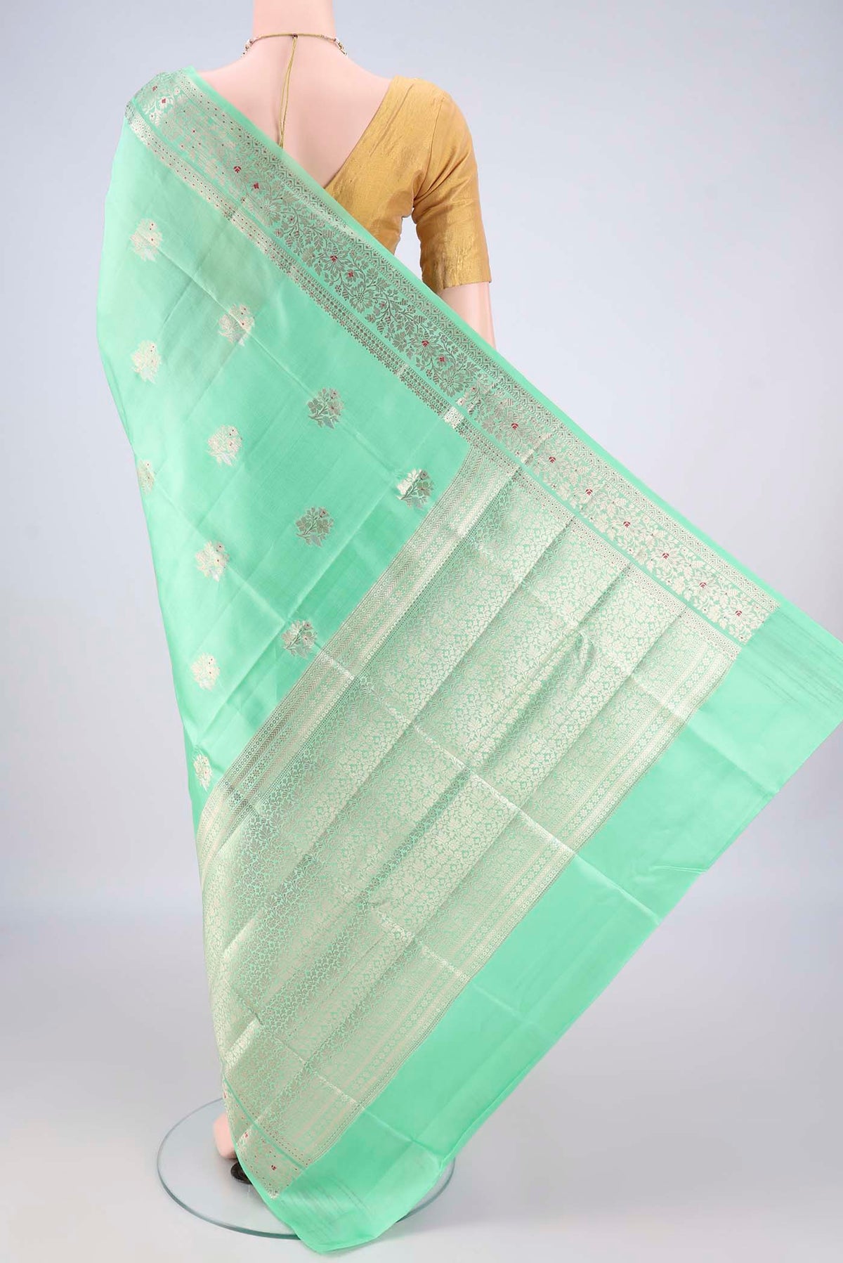Flat view of Pure Silk Mint Green Banarasi Raw Saree with Zari Butta on the body and Zari Border. 