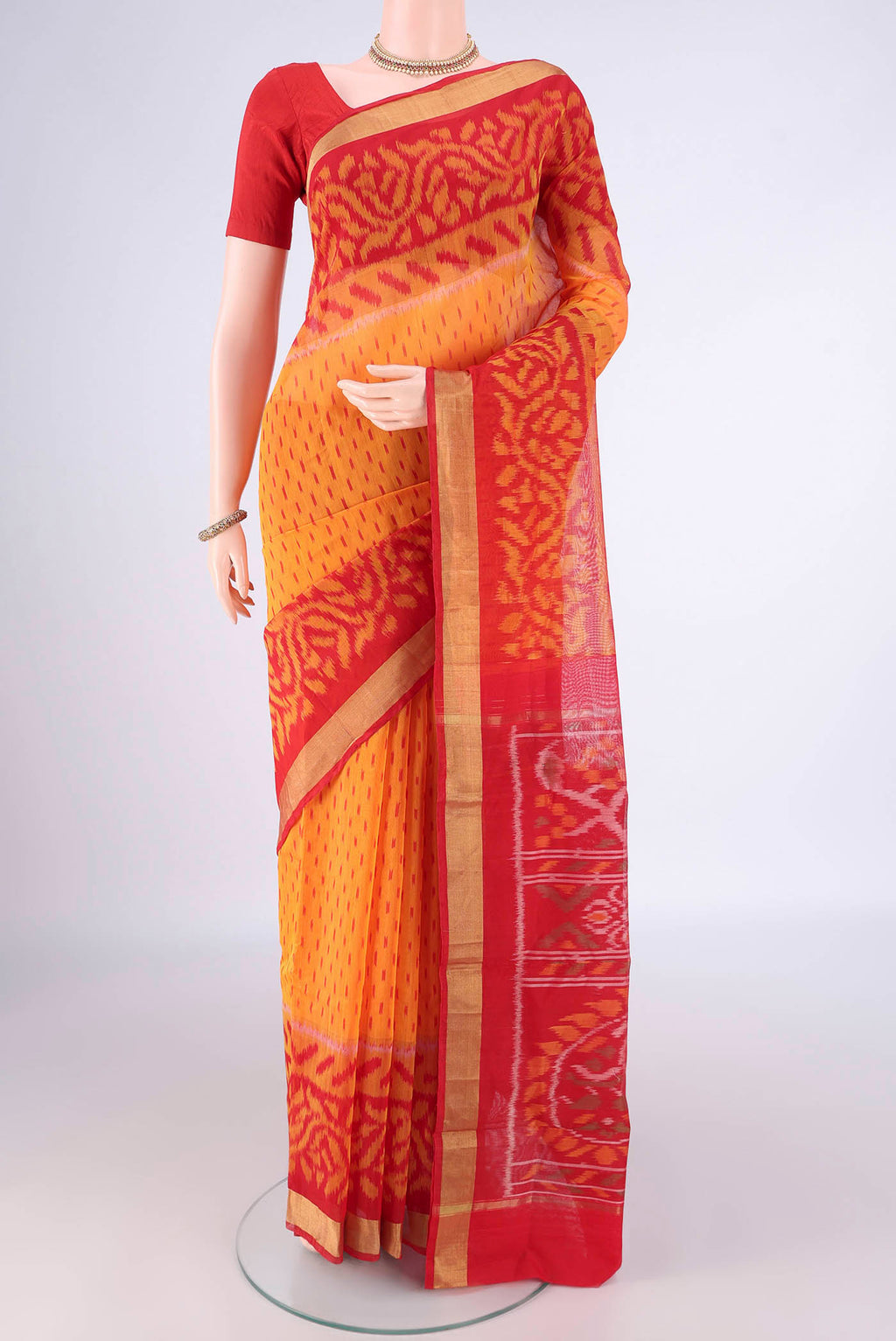 Mustard Silk Cotton Saree with Ikat Print on the body and Ikat Border.  displayed on a mannequin