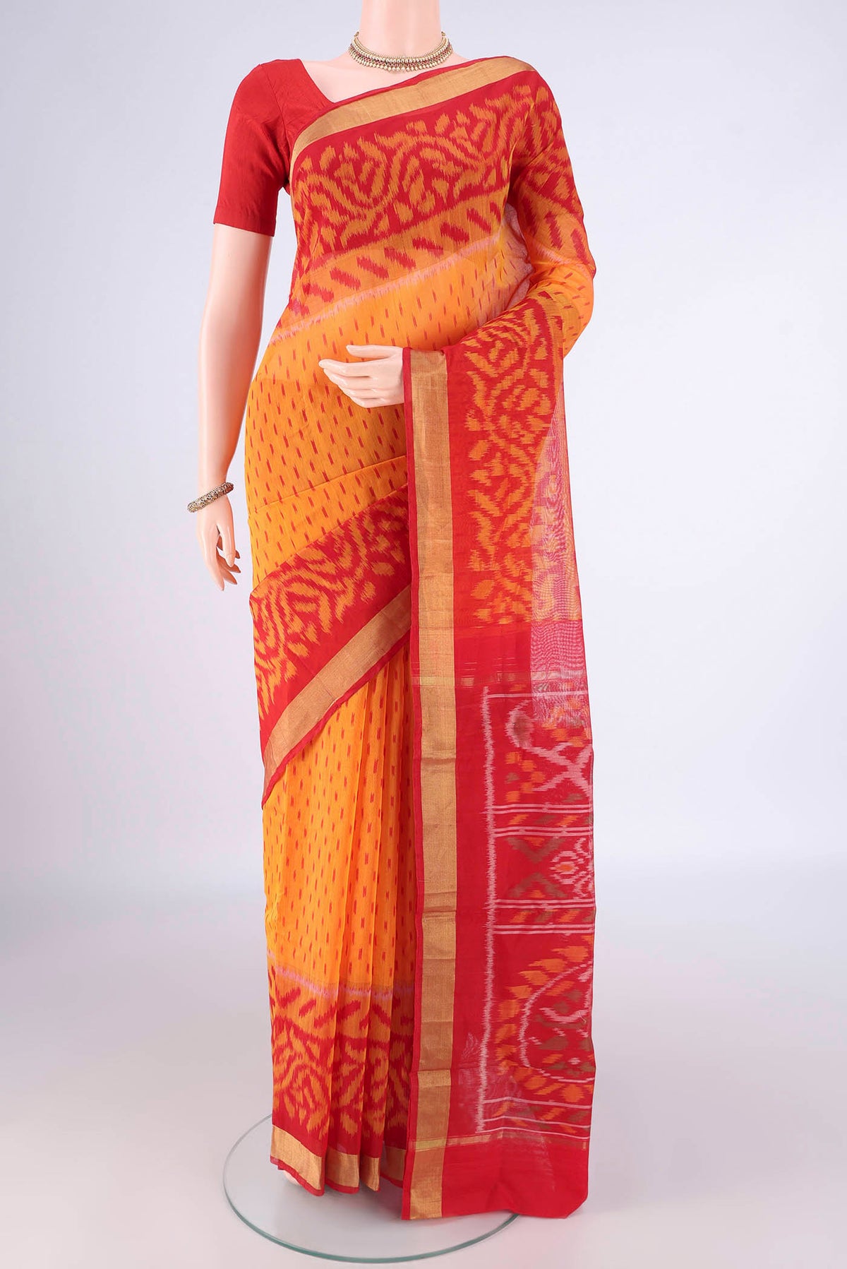Mustard Silk Cotton Saree with Ikat Print on the body and Ikat Border.  displayed on a mannequin