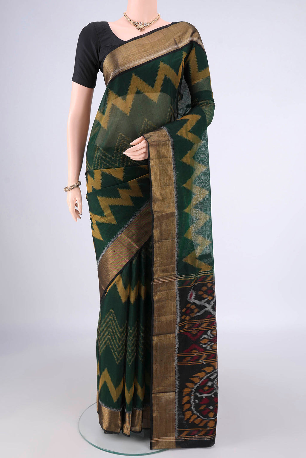 Bottle Green Silk Cotton Saree with Ikat Print on the body and Zari Border.  displayed on a mannequin