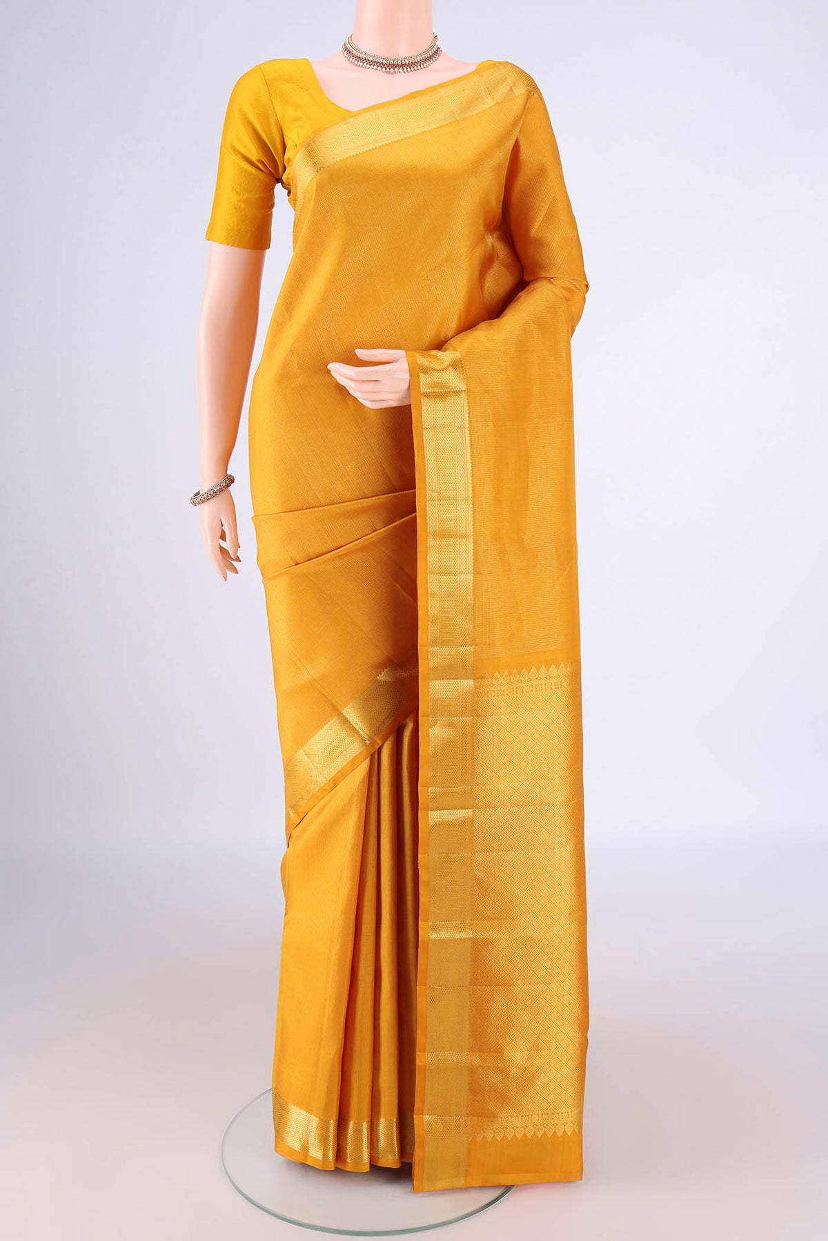 Mustard Kanchipuram Tissue Saree with Stripes on the body and Zari Border.  displayed on a mannequin