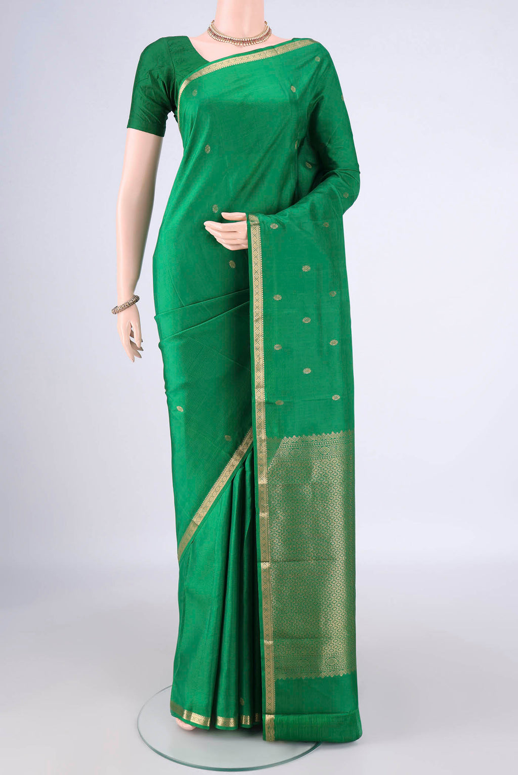 Pure Silk Green Kanjivaram Saree with Zari Butta on the body and Zari Border.  displayed on a mannequin