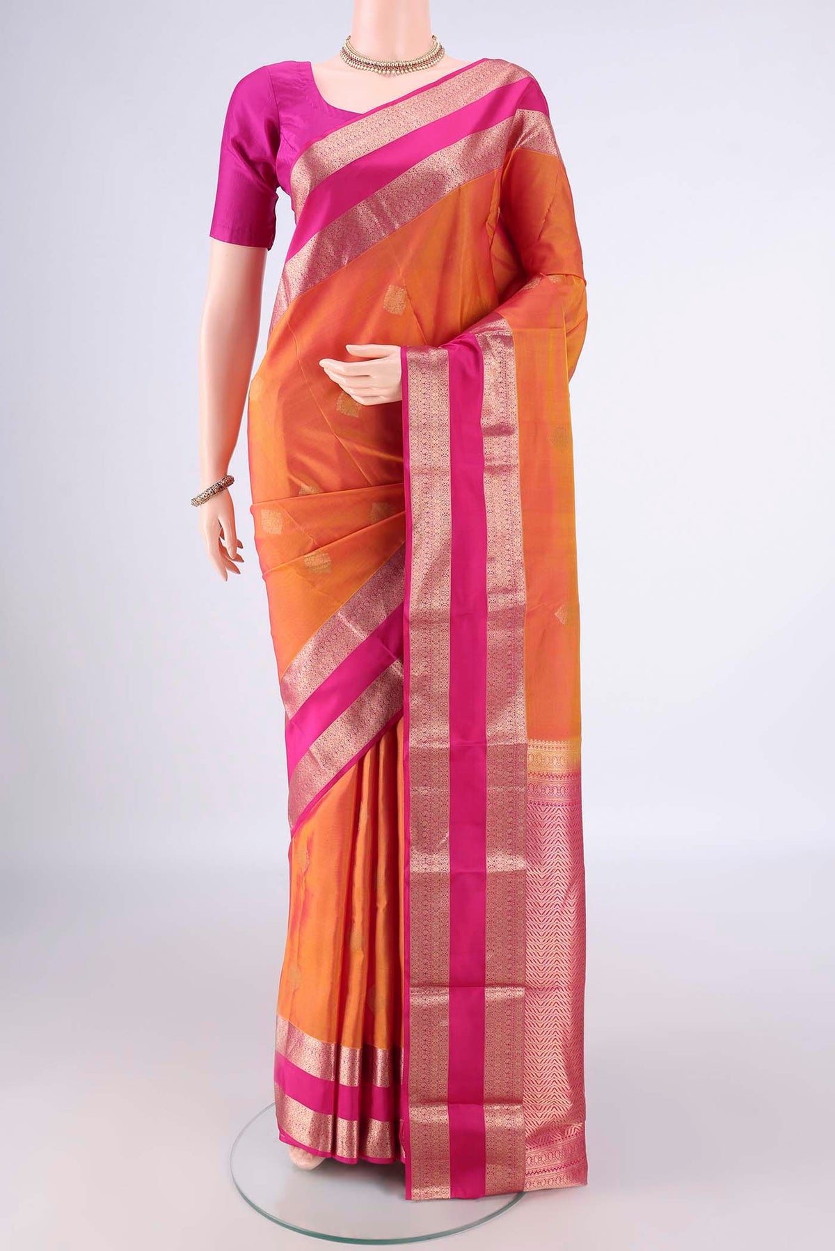 Pure Silk Pinkish Yellow Kanchipuram Saree with Zari Butta on the body and Zari Border.  displayed on a mannequin