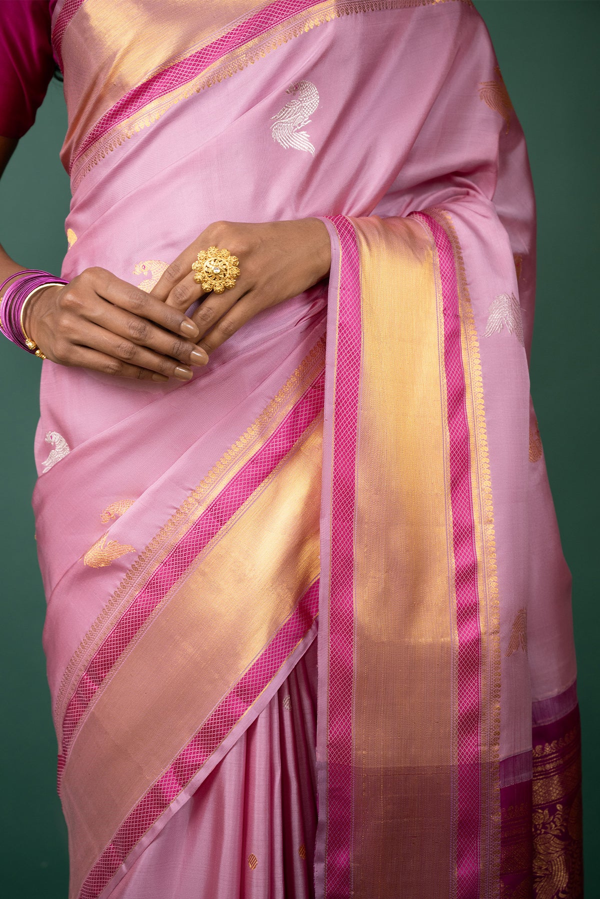 Close up image of the blouse of Pink Kanchipuram Silk Saree with Zari Butta on the body and Zari And Thread Border
