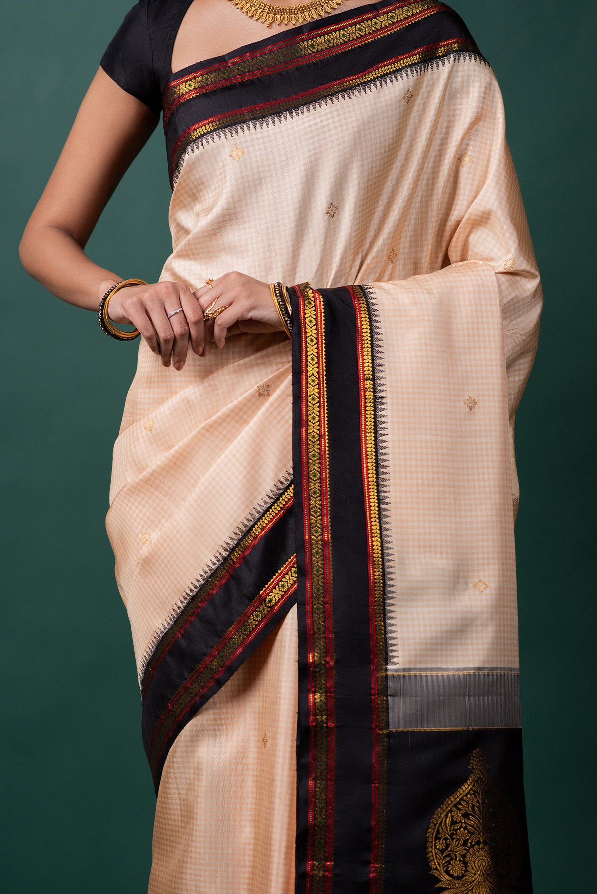 Close up image of the blouse of Off White Kanchipuram Silk Saree with Zari Butta on the body and Zari Border