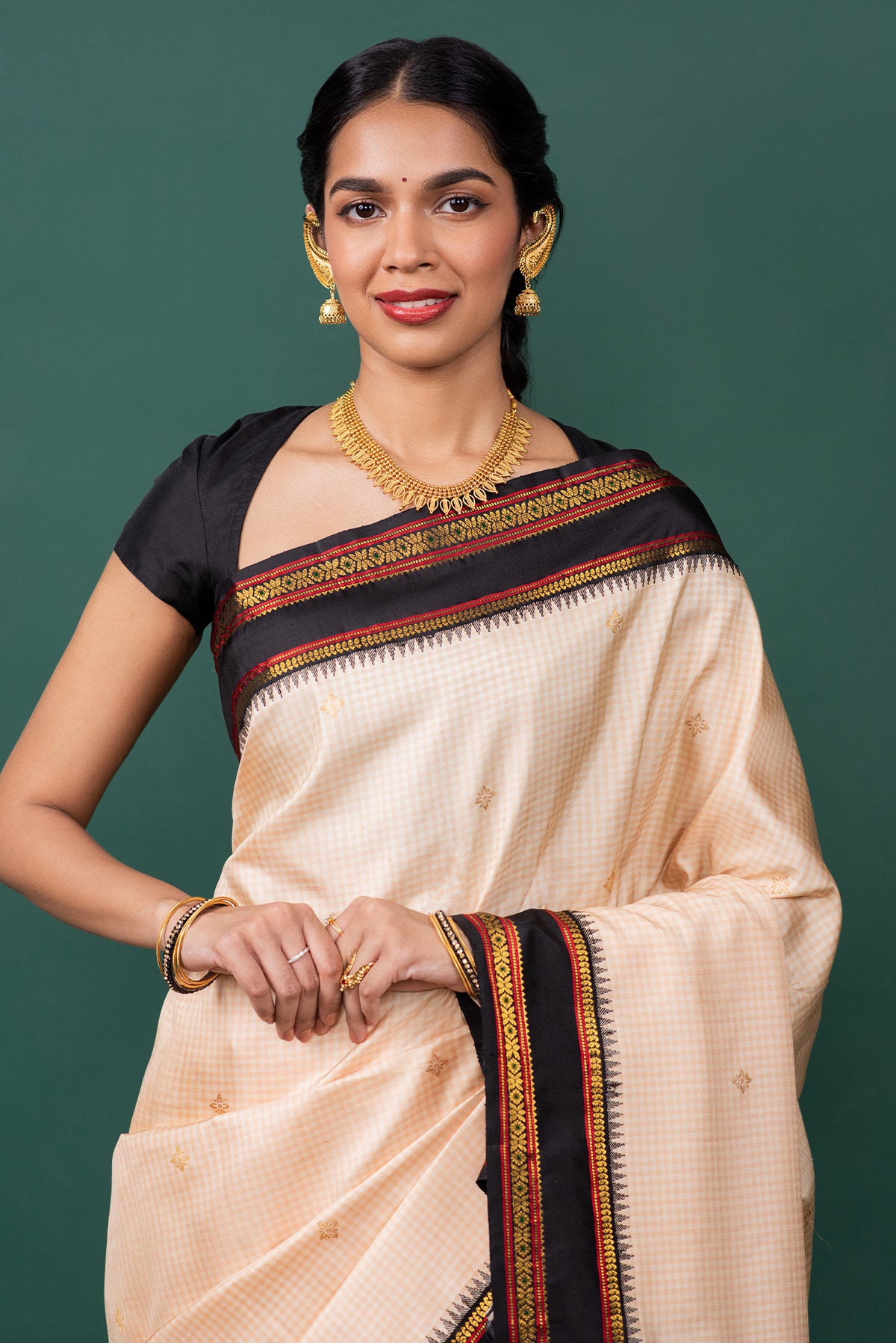 Close up of Off White Kanchipuram Silk Saree with Zari Butta on the body and Zari Border displaying folds