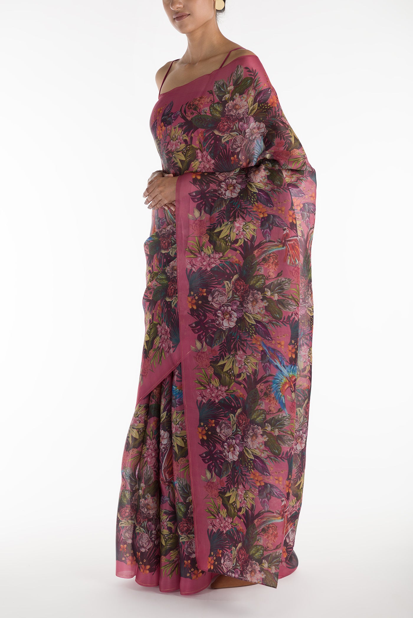 Close up image of the blouse of Our 'Hyacinth Macaws' Satin Organza Saree is crafted in a pink tone that features hand-illustrated tropical prints of macaws flying around tropical florals. The saree is completed with the sheen of detailed thin Zari lines.