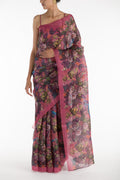 Our 'Hyacinth Macaws' Satin Organza Saree is crafted in a pink tone that features hand-illustrated tropical prints of macaws flying around tropical florals. The saree is completed with the sheen of detailed thin Zari lines. displayed on a mannequin