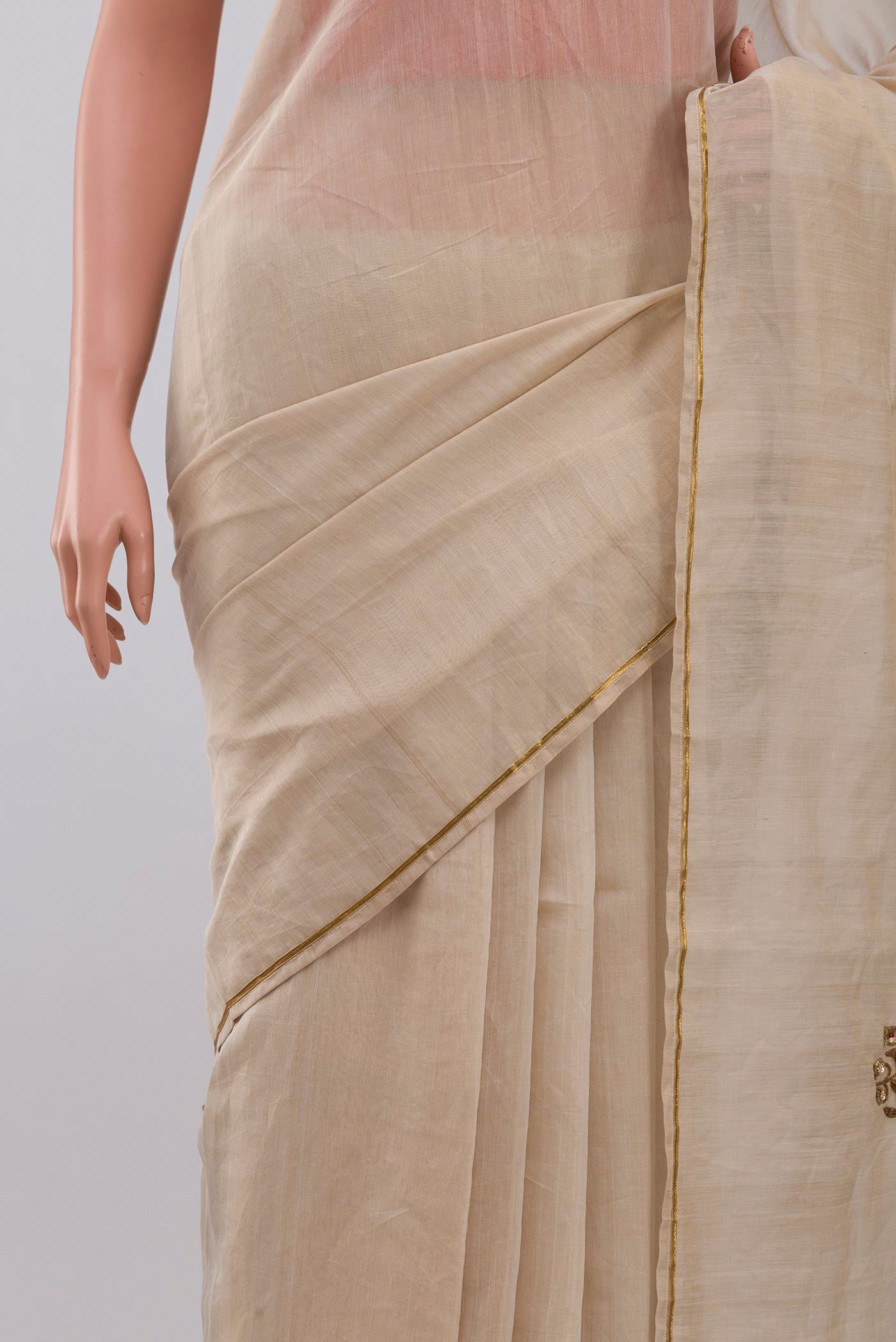 Close up of Beige Chanderi Silk Cotton Saree with Embroidery on the body and Thin Zari Line displaying folds