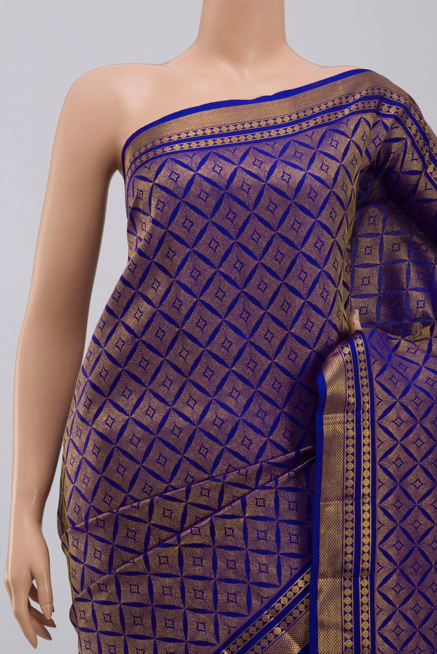 Border image of Handwoven in pure mulberry silk with half-fine gold and silver zari, this blue Kanjeevaram saree celebrates the harmony of line and light. A refined checkered pattern, formed by intersecting gold zari lines, unfolds across the body and continues into the radiant gold pallu. Framed by two broad gold bands separated by a slender gold stripe, the border lends the weave timeless balance and elegance.