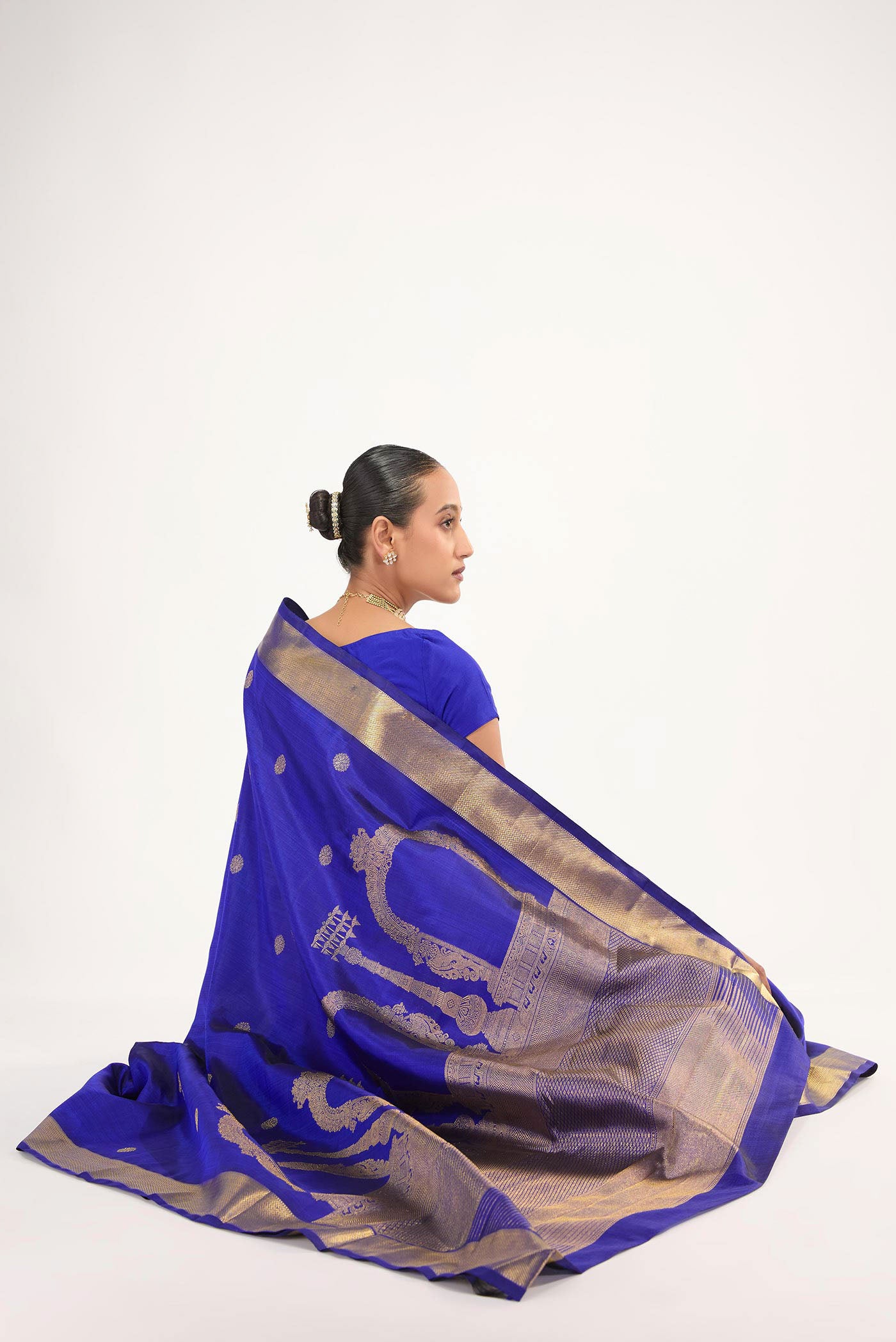 Close up image of the blouse of Thiruvakshi is inspired by Dravidian architecture with iconic gopurams, mandapas & kodimarams The pallu features Prabhavali (circle of flames) with powerful Yaali flanked by Gajja Yalis Kodimarams alternate as temple flagposts symbolising Lord Brahma with Brahma Kamal Ghetti border with minnal pet frames and kamalam buttas in the body
Technique: Handwoven