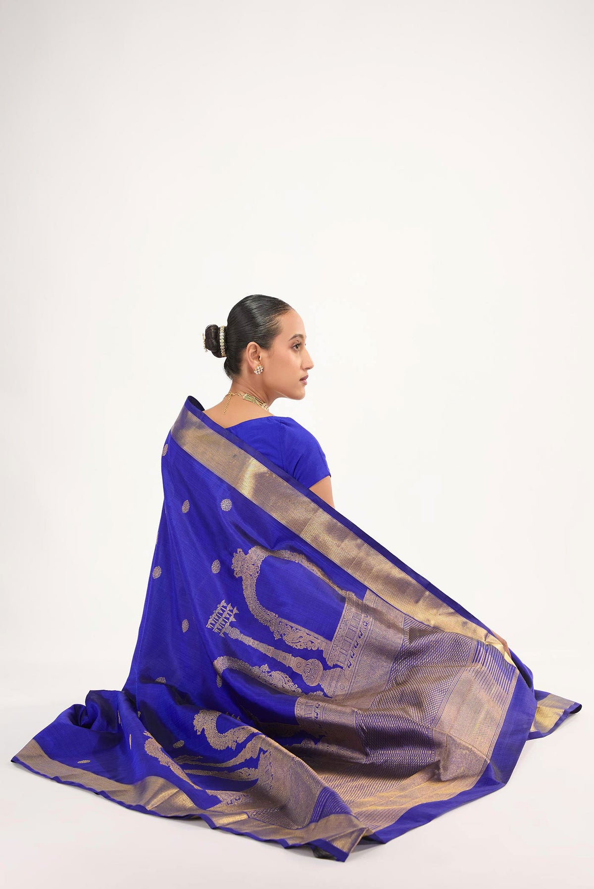 Close up image of the blouse of Thiruvakshi is inspired by Dravidian architecture with iconic gopurams, mandapas & kodimarams The pallu features Prabhavali (circle of flames) with powerful Yaali flanked by Gajja Yalis Kodimarams alternate as temple flagposts symbolising Lord Brahma with Brahma Kamal Ghetti border with minnal pet frames and kamalam buttas in the body
Technique: Handwoven