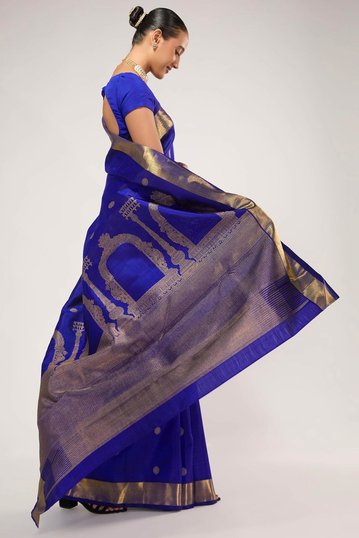 Close up image of the pallu of Thiruvakshi is inspired by Dravidian architecture with iconic gopurams, mandapas & kodimarams The pallu features Prabhavali (circle of flames) with powerful Yaali flanked by Gajja Yalis Kodimarams alternate as temple flagposts symbolising Lord Brahma with Brahma Kamal Ghetti border with minnal pet frames and kamalam buttas in the body
Technique: Handwoven