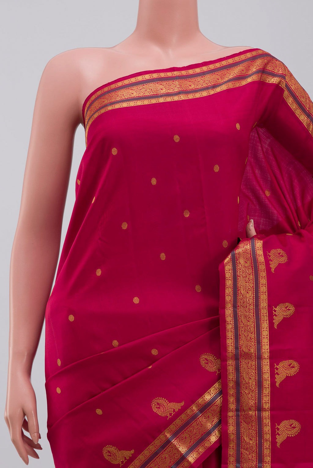 Border image of Aaradhya unfolds in a vibrant scarlet red, adorned with delicate rudraksh butas that bring depth and rhythm to the weave. The 3-inch borders feature mayil zari pet and rudraksh pet framed by contrasting silk bands. Along the lower border, graceful mayils with unfurled wings create a striking visual detail. The pallu is highlighted by a distinctive grid pattern accented with vibrant green bands