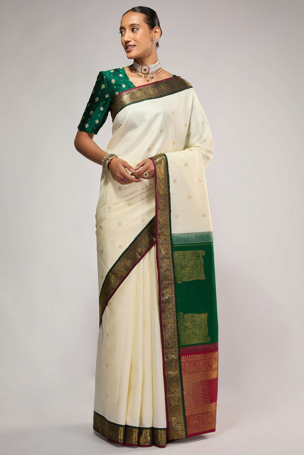 Off White Kanchipuram Silk Saree with Zari Butta on the body and Zari Border displayed on a mannequin
