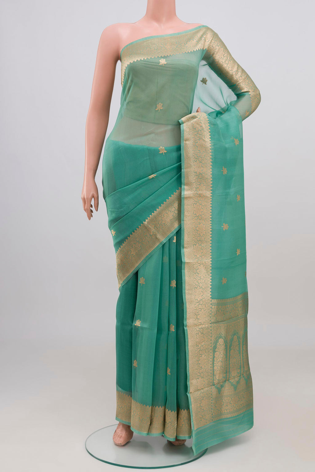 Green Organza Silk Saree with Zari Butta on the body and Zari Border displayed on a mannequin