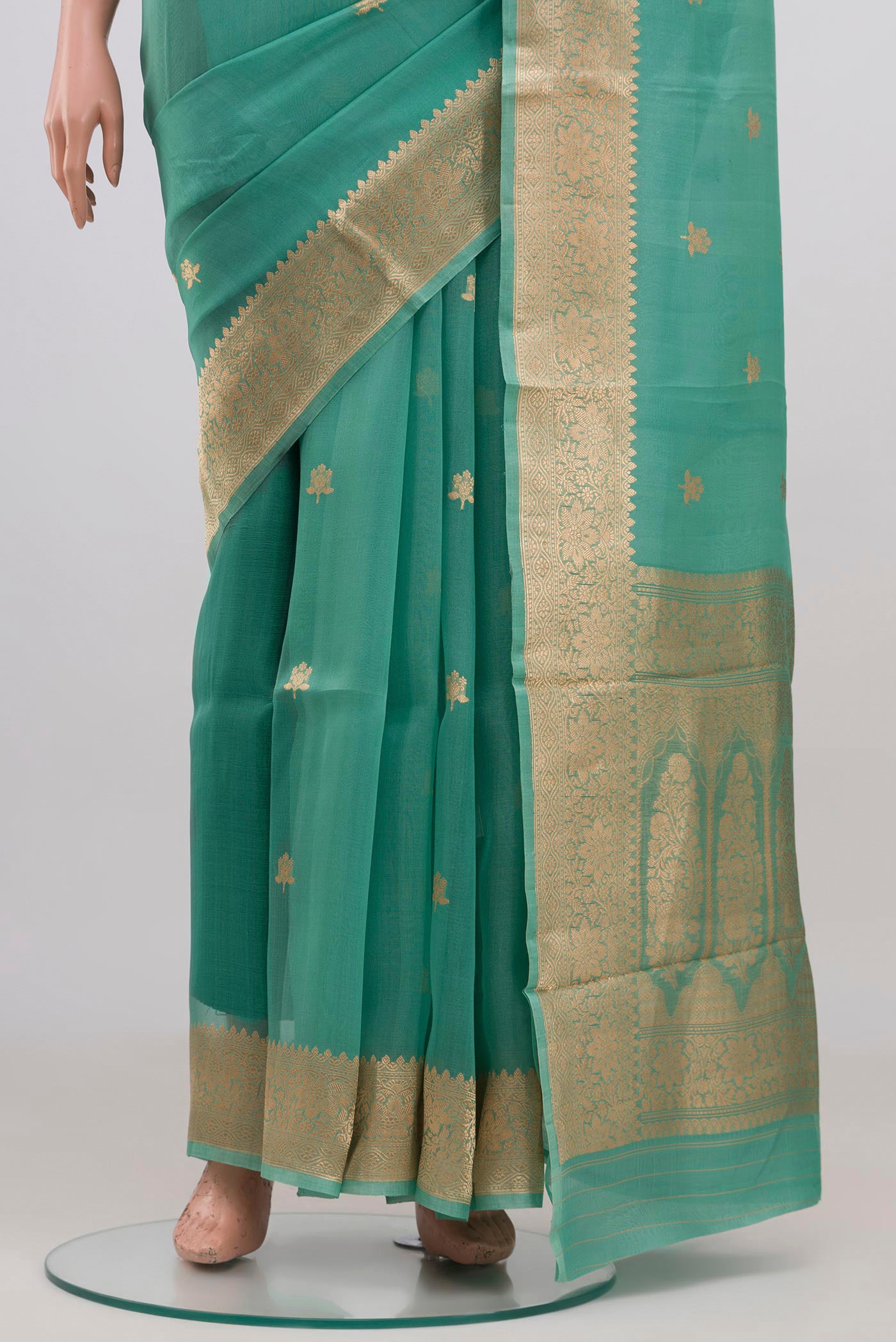 Pleats and pallu of Green Organza Silk Saree with Zari Butta on the body and Zari Border