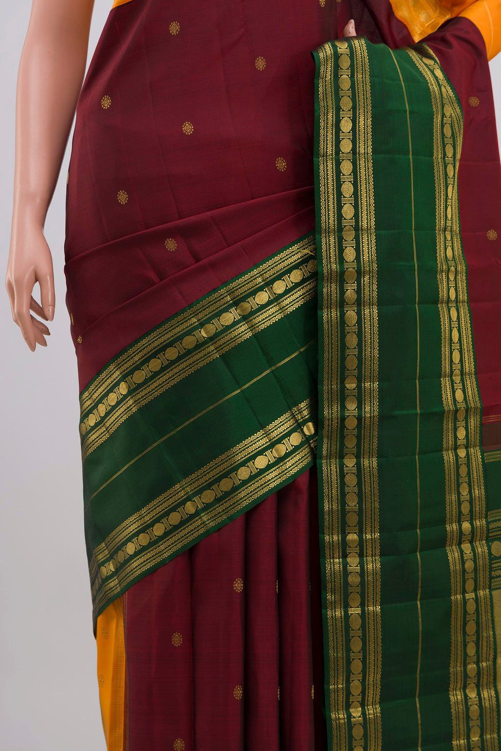 Close up of Maroon Kanchipuram Silk Saree with Zari Butta on the body and Ganga Jamuna Border displaying folds