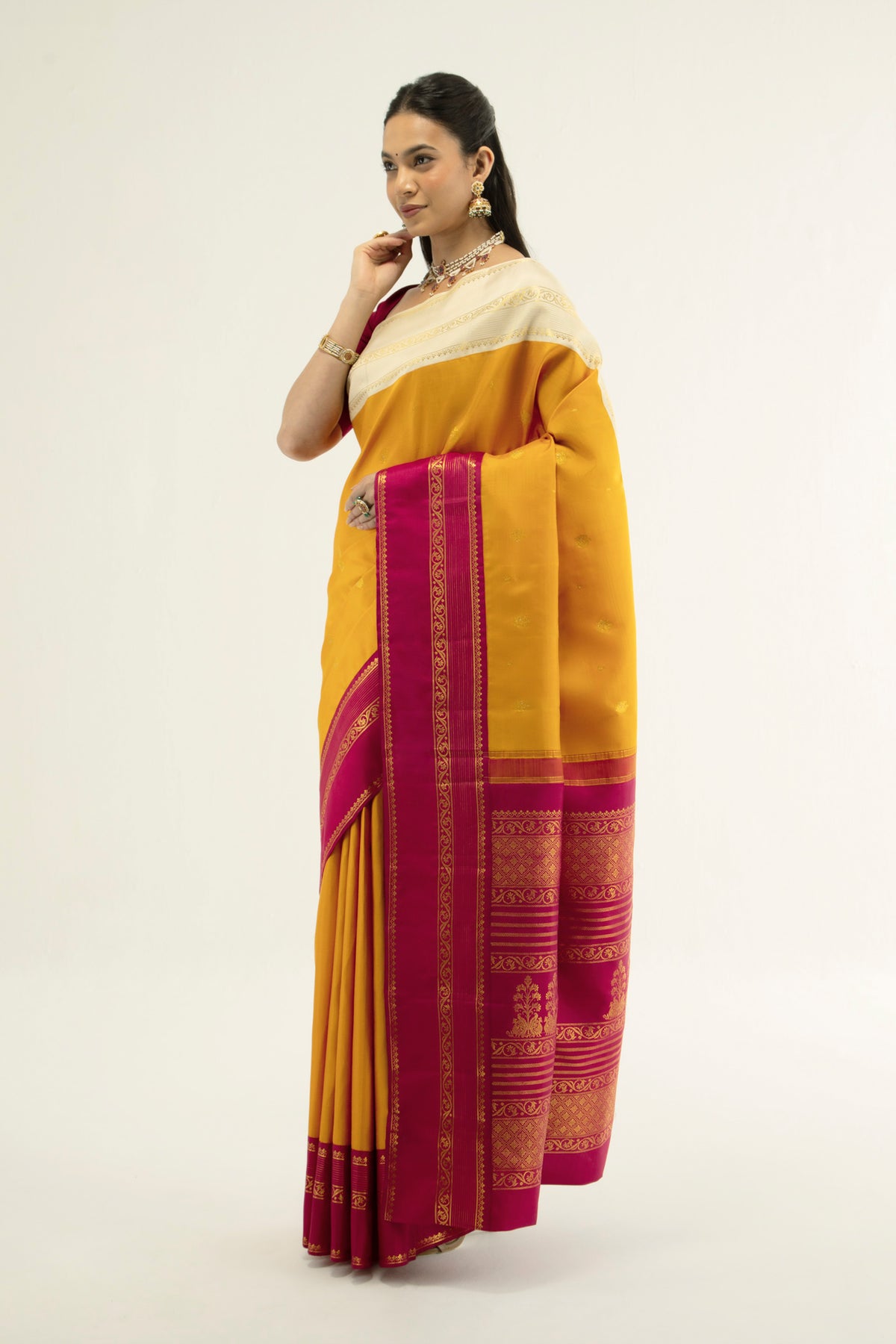 Close up of Yellow Kanchipuram Silk Saree with Zari Butta on the body and Ganga Jamuna Border displaying folds