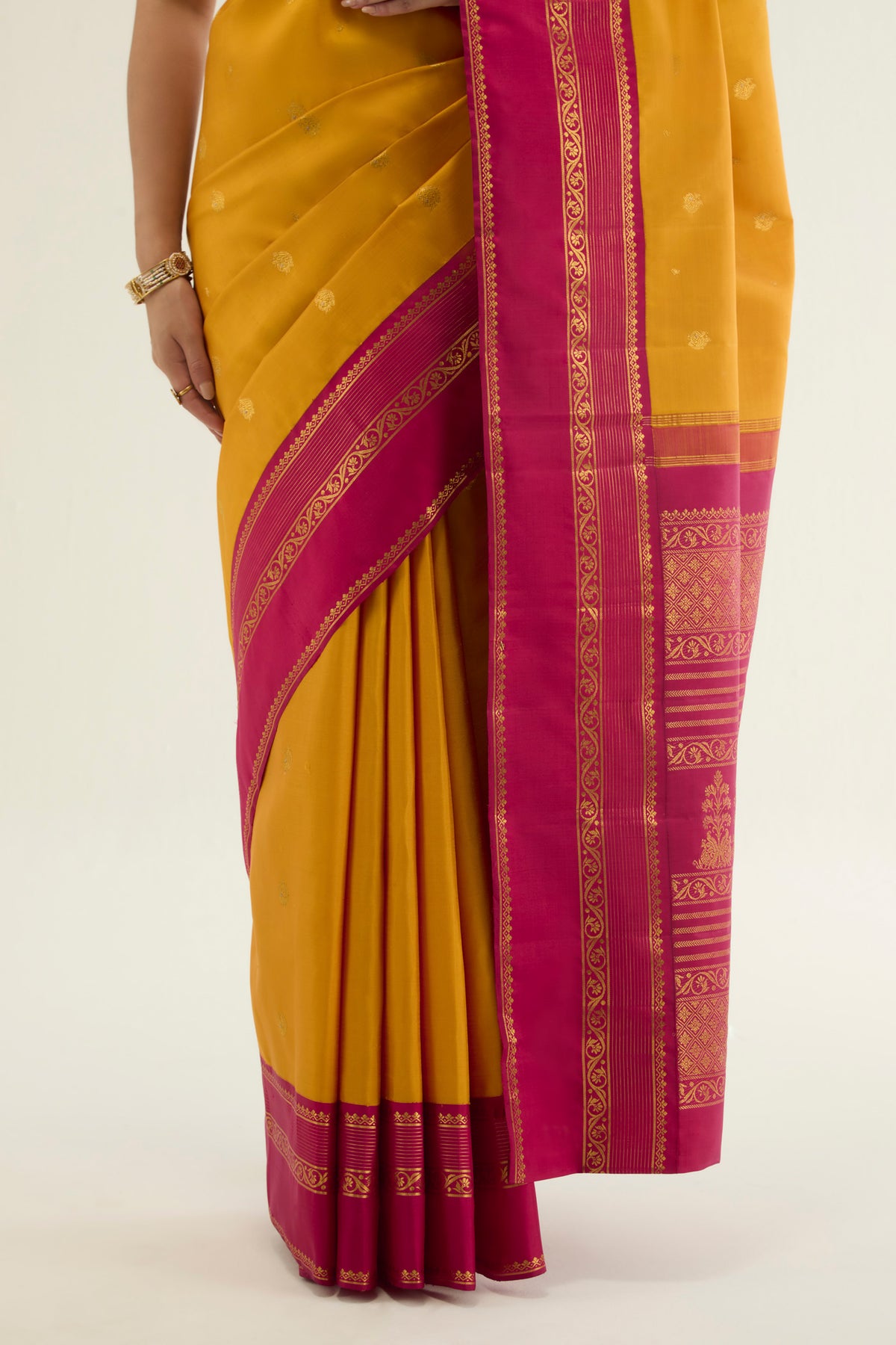 Pleats and pallu of Yellow Kanchipuram Silk Saree with Zari Butta on the body and Ganga Jamuna Border