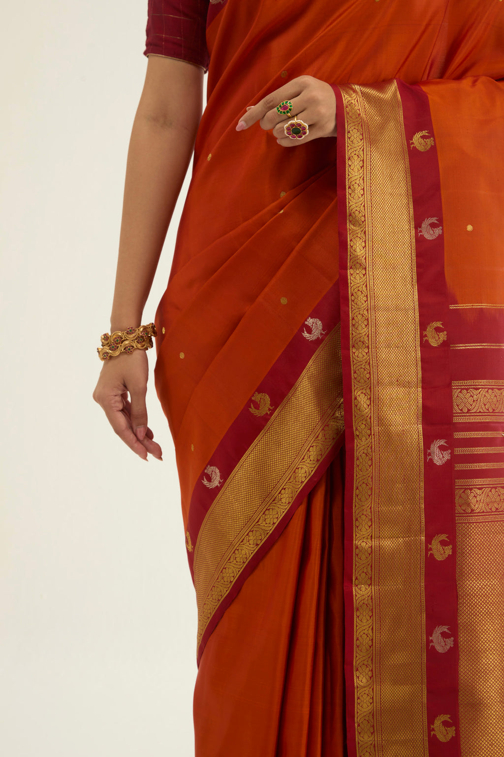 Close up image of the blouse of Orange Kanchipuram Silk Saree with Zari Butta on the body and Zari Border