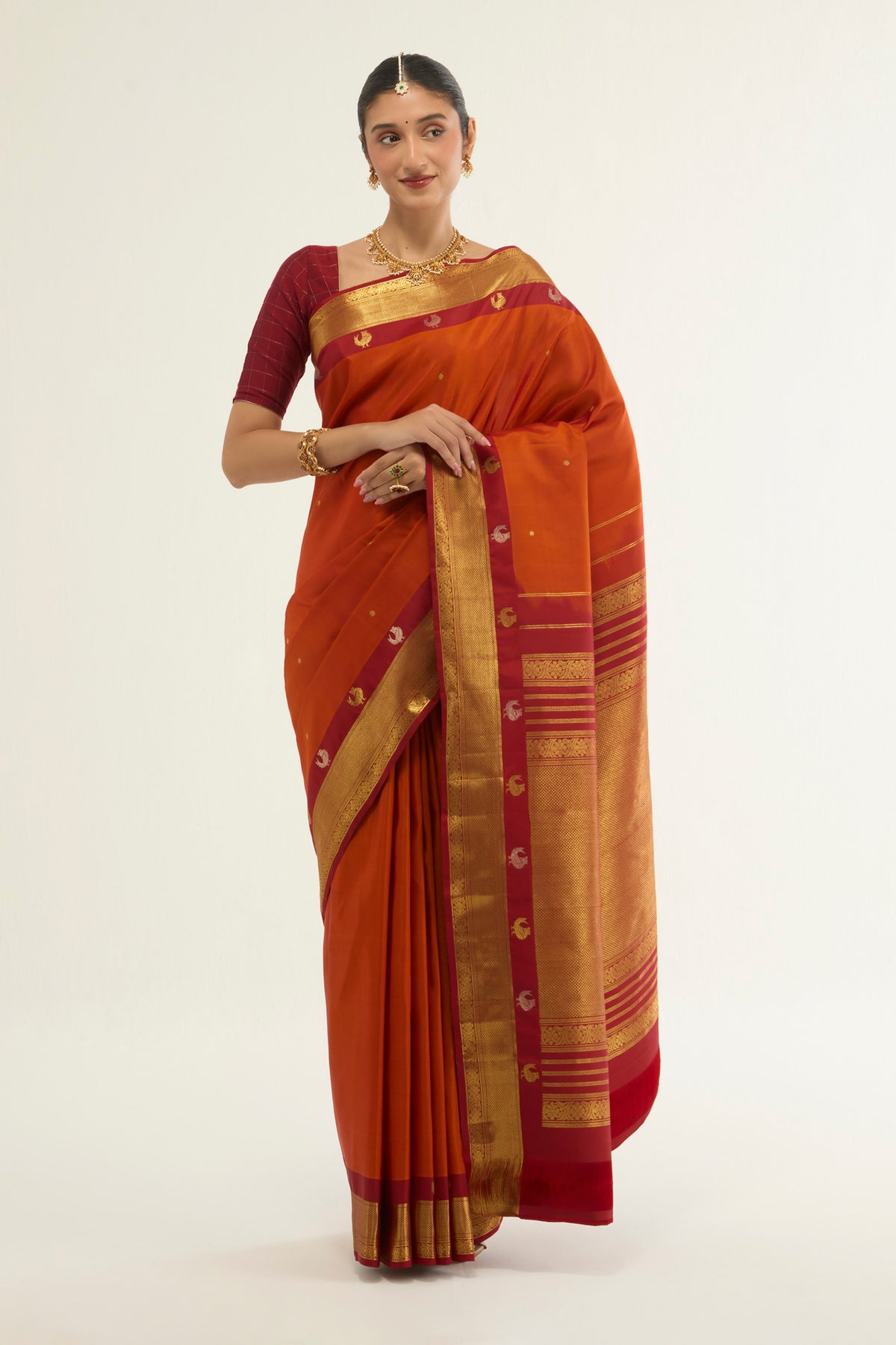 Orange Kanchipuram Silk Saree with Zari Butta on the body and Zari Border displayed on a mannequin