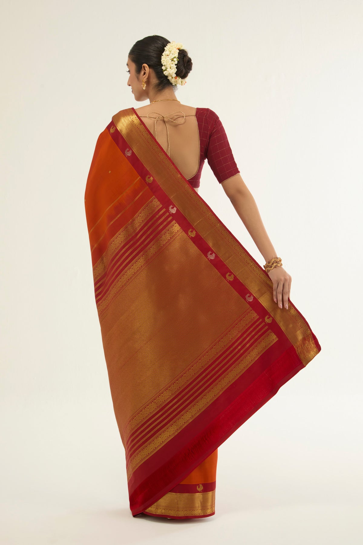 Flat view of Orange Kanchipuram Silk Saree with Zari Butta on the body and Zari Border