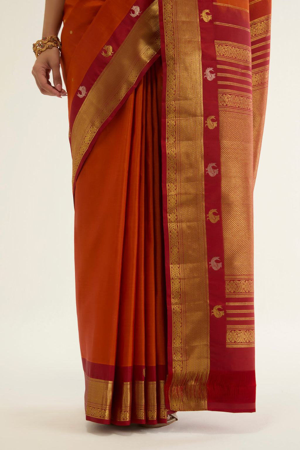 Pleats and pallu of Orange Kanchipuram Silk Saree with Zari Butta on the body and Zari Border