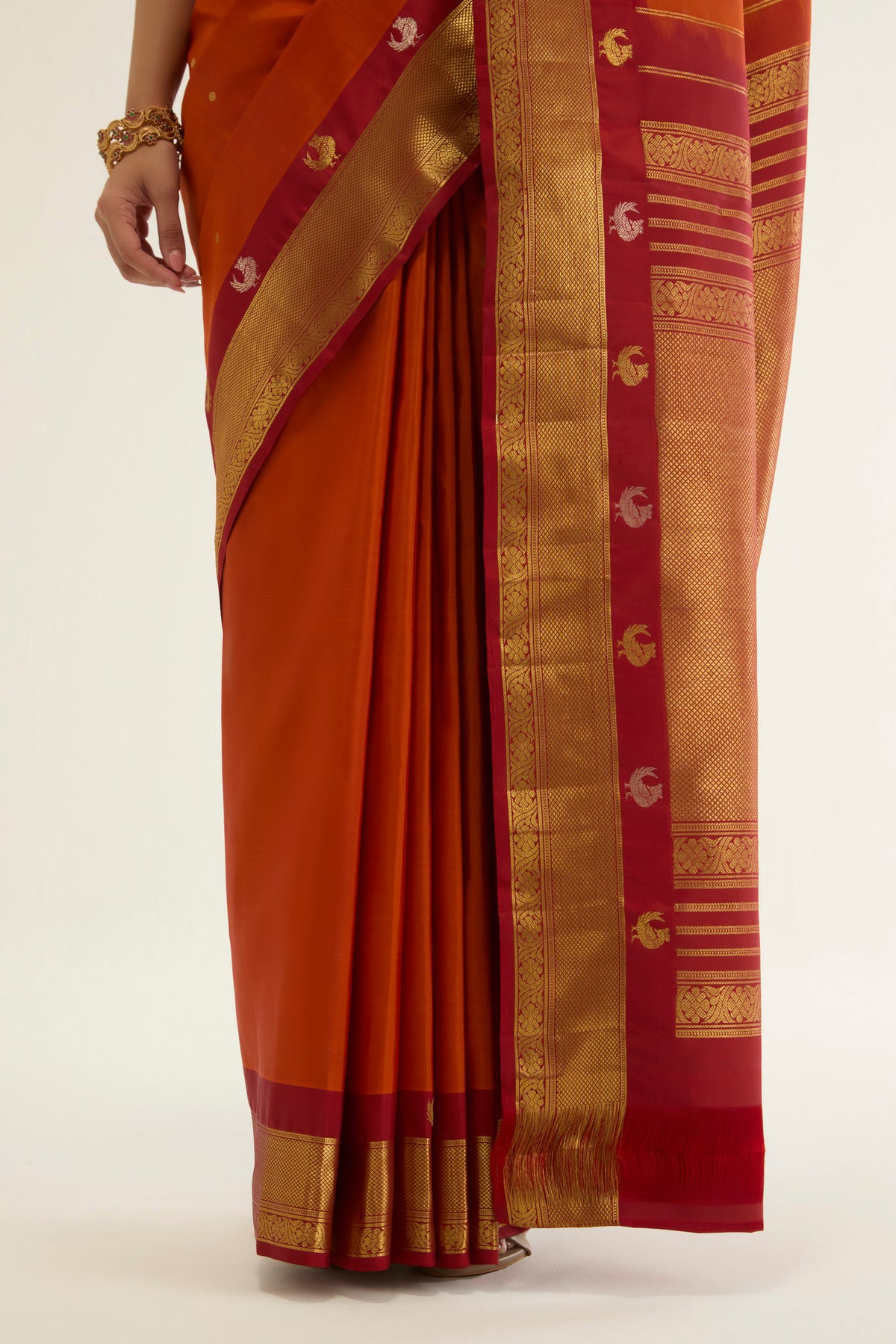 Pleats and pallu of Orange Kanchipuram Silk Saree with Zari Butta on the body and Zari Border