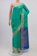 Green Raw Silk Saree with Zari Butta on the body and Zari Border.  displayed on a mannequin
