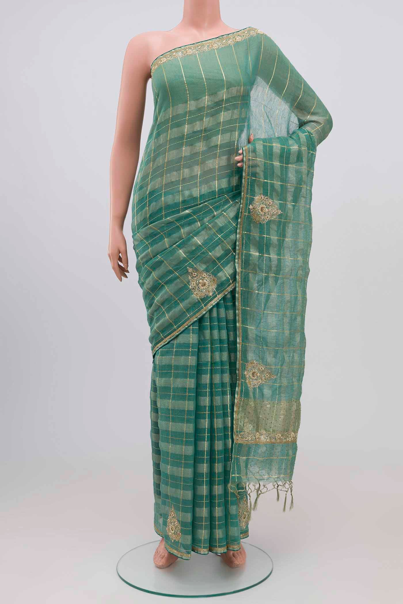 Green Linen Saree with Checked design on the body and Embroidery Border.  displayed on a mannequin
