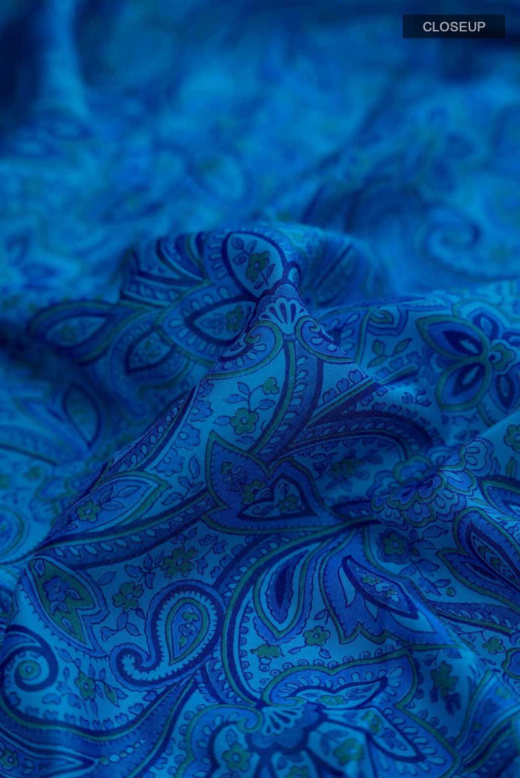 Close up of Blue Blended Crepe Saree with Floral Print on the body and Zari Border.  displaying folds