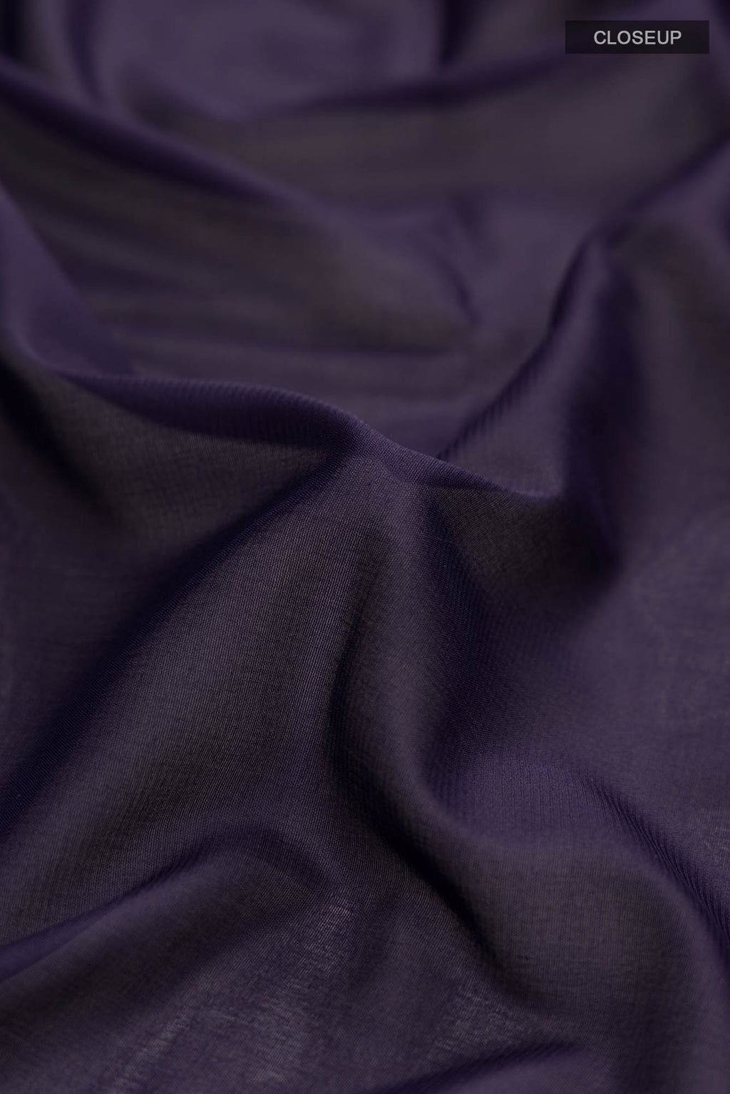 Close up of Navy Blue Blended Crepe Saree with Plain Body and Zari Border.  displaying folds